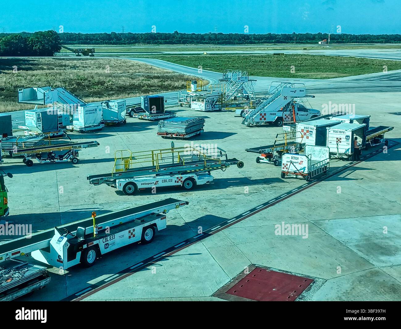 Cancun, Quintana Roo, Mexique – le 26 novembre 2024 : le matériel de soutien au sol et les conteneurs de fret sont prêts sur le tarmac de l’aéroport international de Cancun Banque D'Images