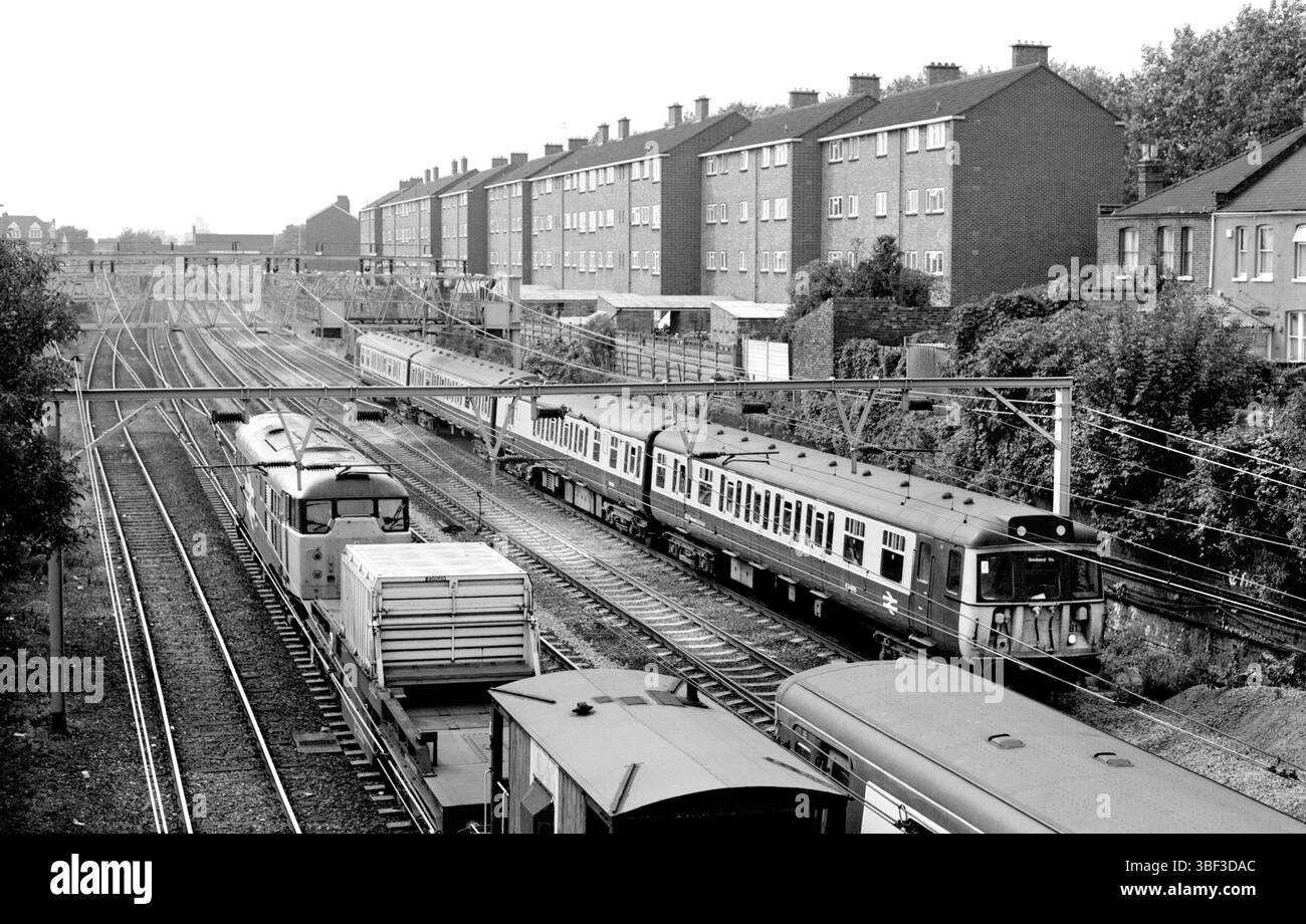 Un train à flasques nucléaires passe devant des trains de voyageurs dans l'est de Londres, près de la gare d'Ilford. Banque D'Images