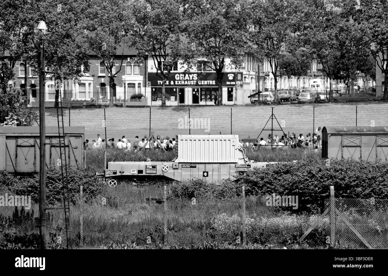 Un train à fioles de combustible nucléaire passe devant des enfants dans un terrain de jeu scolaire à l'est de Londres. Contexte : Leyton Road, E15. La fiole était en route d'une centrale nucléaire d'East Anglia (Sizewell ou Bradwell) à Sellafield, Cumbria. Banque D'Images