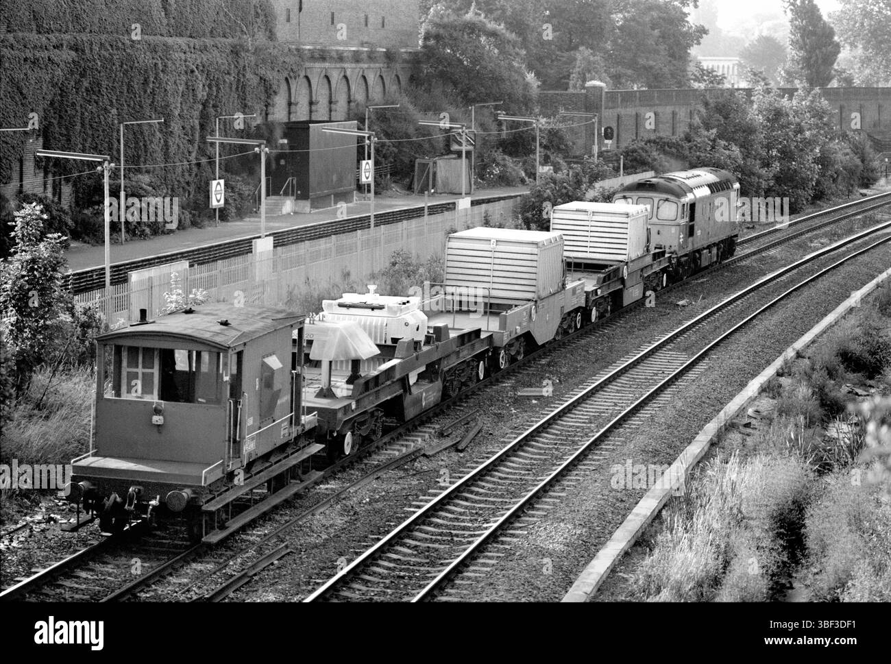 Un train à flasques nucléaires passant devant la station de métro West Brompton sur la West London Line. Photographie prise en 1986 alors que certains flacons étaient encore transportés à découvert. Les flacons ont depuis été dissimulés sous des carters métalliques, comme sur les deux wagons avant. Cet emplacement est maintenant le site de la station aérienne West Brompton. Banque D'Images