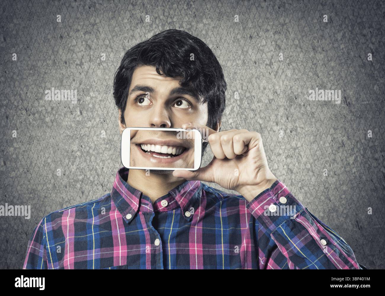 Jeune homme tenant un smartphone avec le sourire à l'écran Banque D'Images