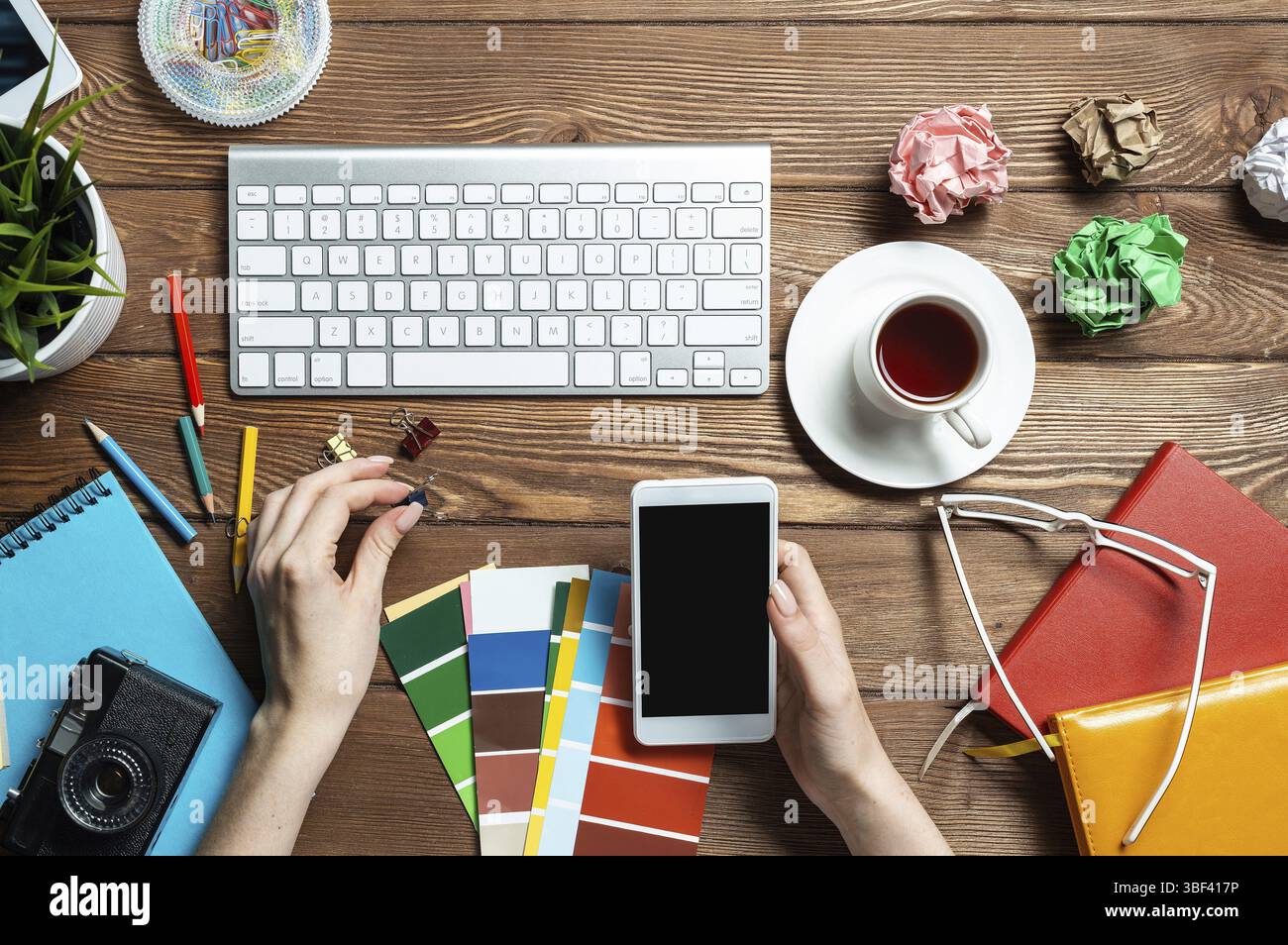 Concepteur Web choisissant des couleurs à partir de nuances au bureau en bois. Bureau vue de dessus avec clavier d'ordinateur et papeterie. Conception de l'interface utilisateur o Banque D'Images