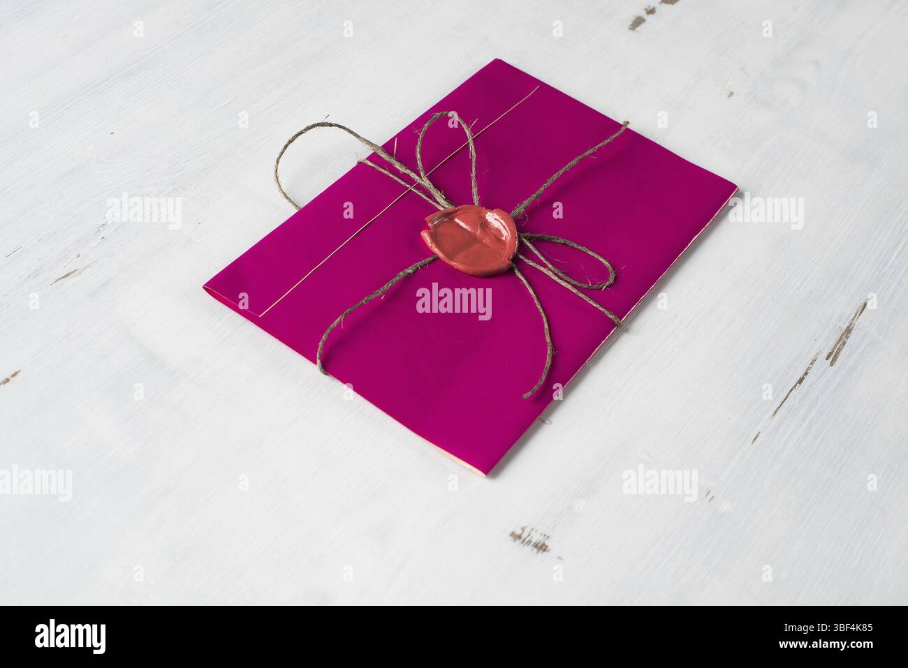 Lettre rose enveloppe avec cachet de cire sur la surface en bois Banque D'Images