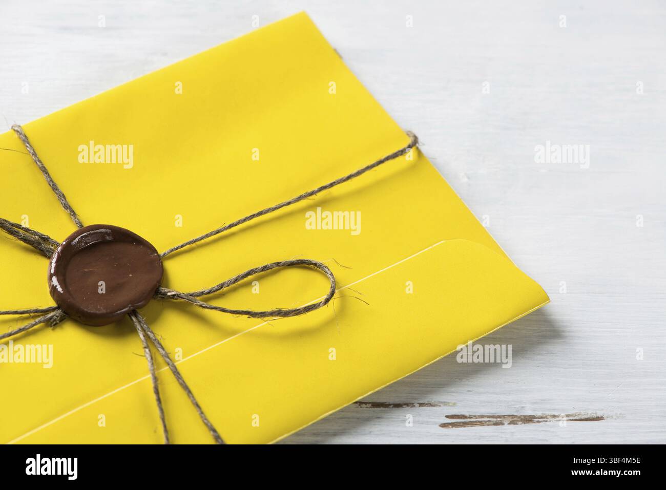Lettre jaune enveloppe avec cachet de cire sur la surface en bois Banque D'Images