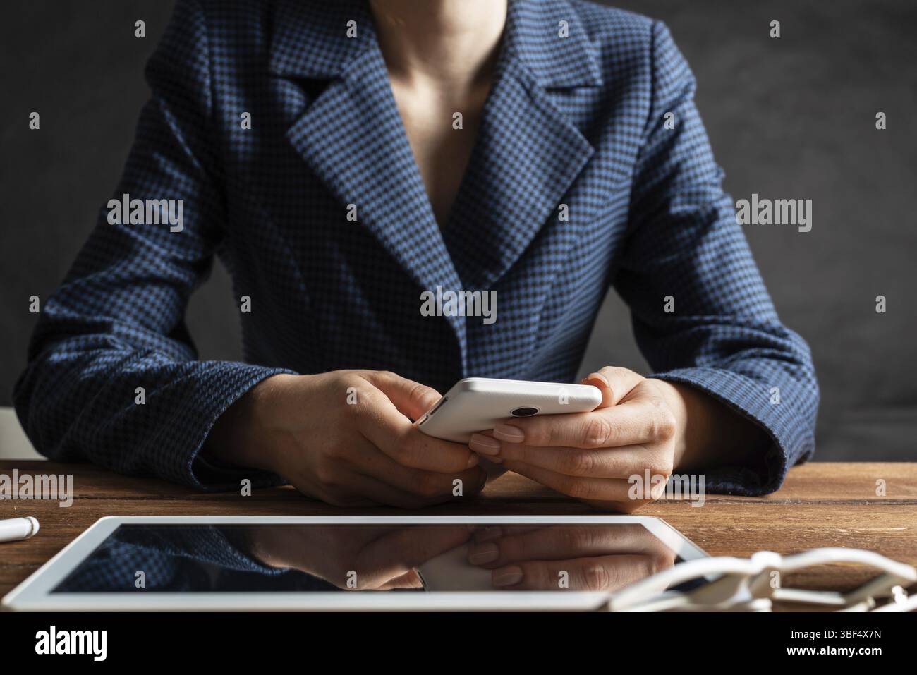 Femme d'affaires utilisant le téléphone portable au bureau. Fermez les mains de la femme et la tablette. Concept de communication mobile avec chat femme. Technolo numérique Banque D'Images