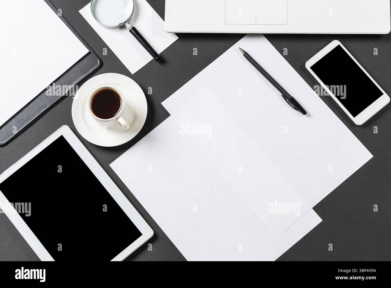 Vue de dessus du lieu de travail design avec des appareils numériques modernes. Design élégant à plat avec surface noire et espace de copie. Technologie numérique et mobile l Banque D'Images