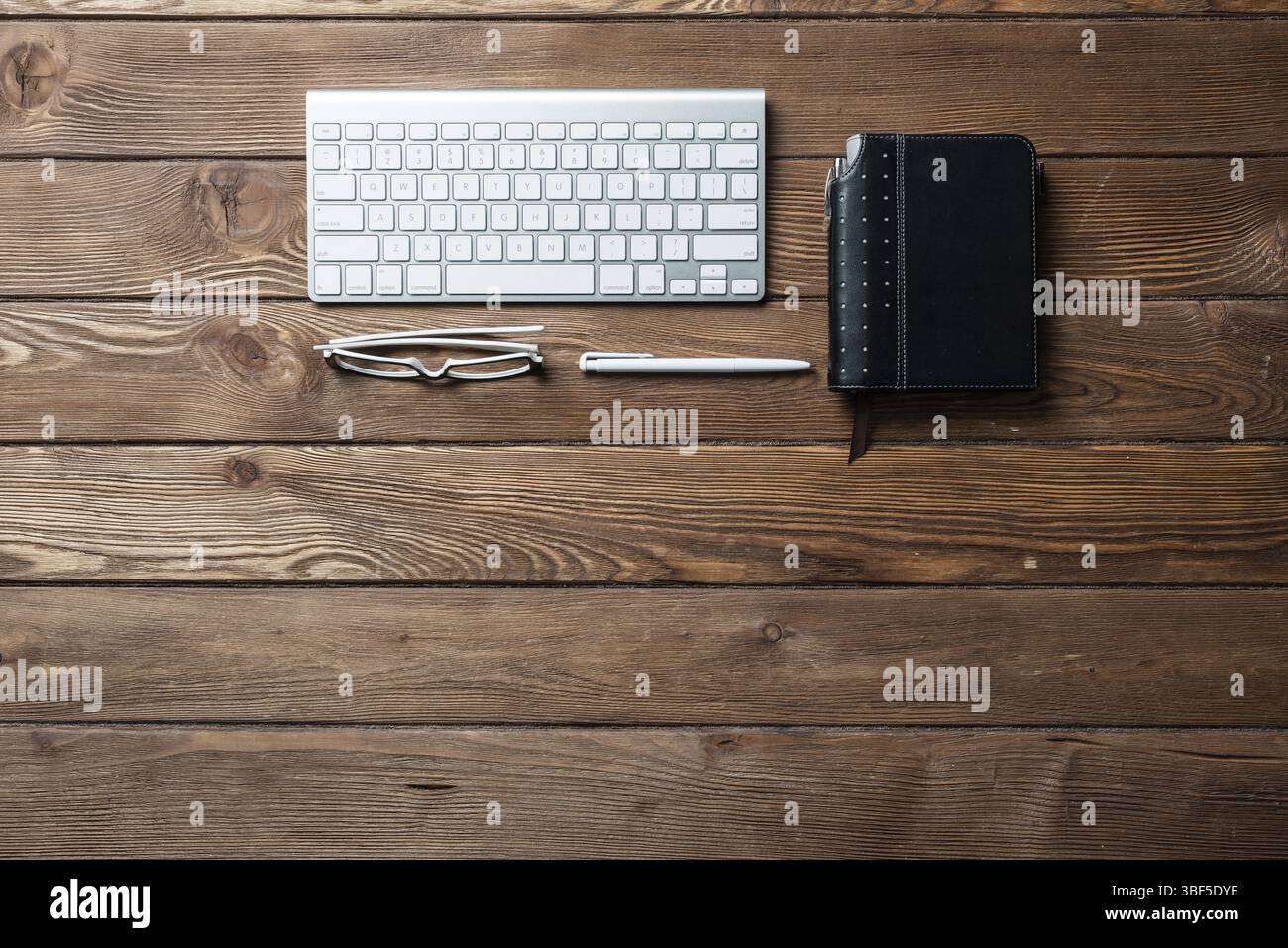 Nature morte de l'espace de travail de bureau avec fournitures. Ancien bureau vintage plat avec ordinateur portable organisateur et clavier d'ordinateur. Gestion du temps et planning journalier Banque D'Images
