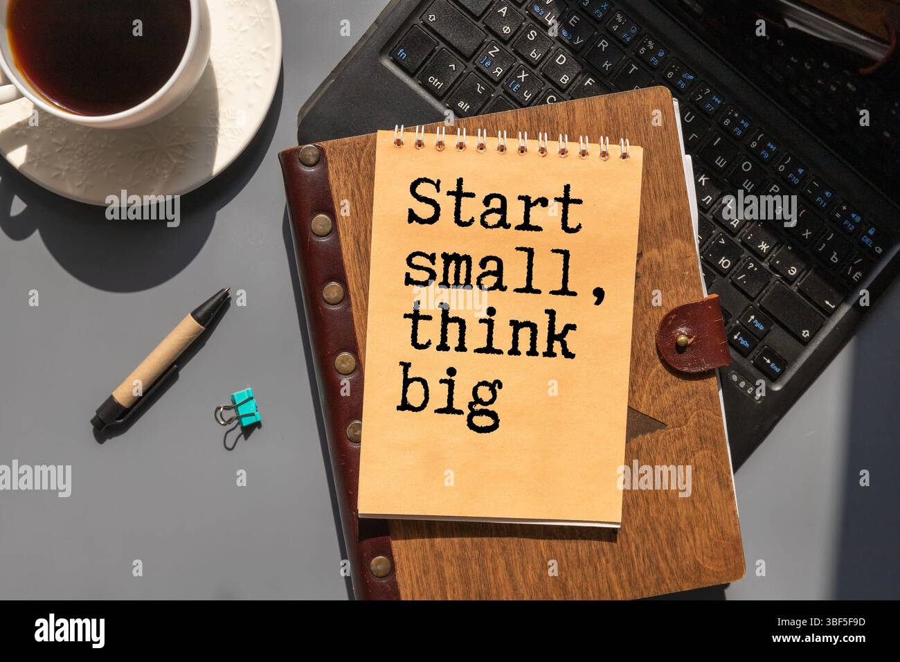 Homme avec une note et un mot commencer petit voir grand Banque D'Images