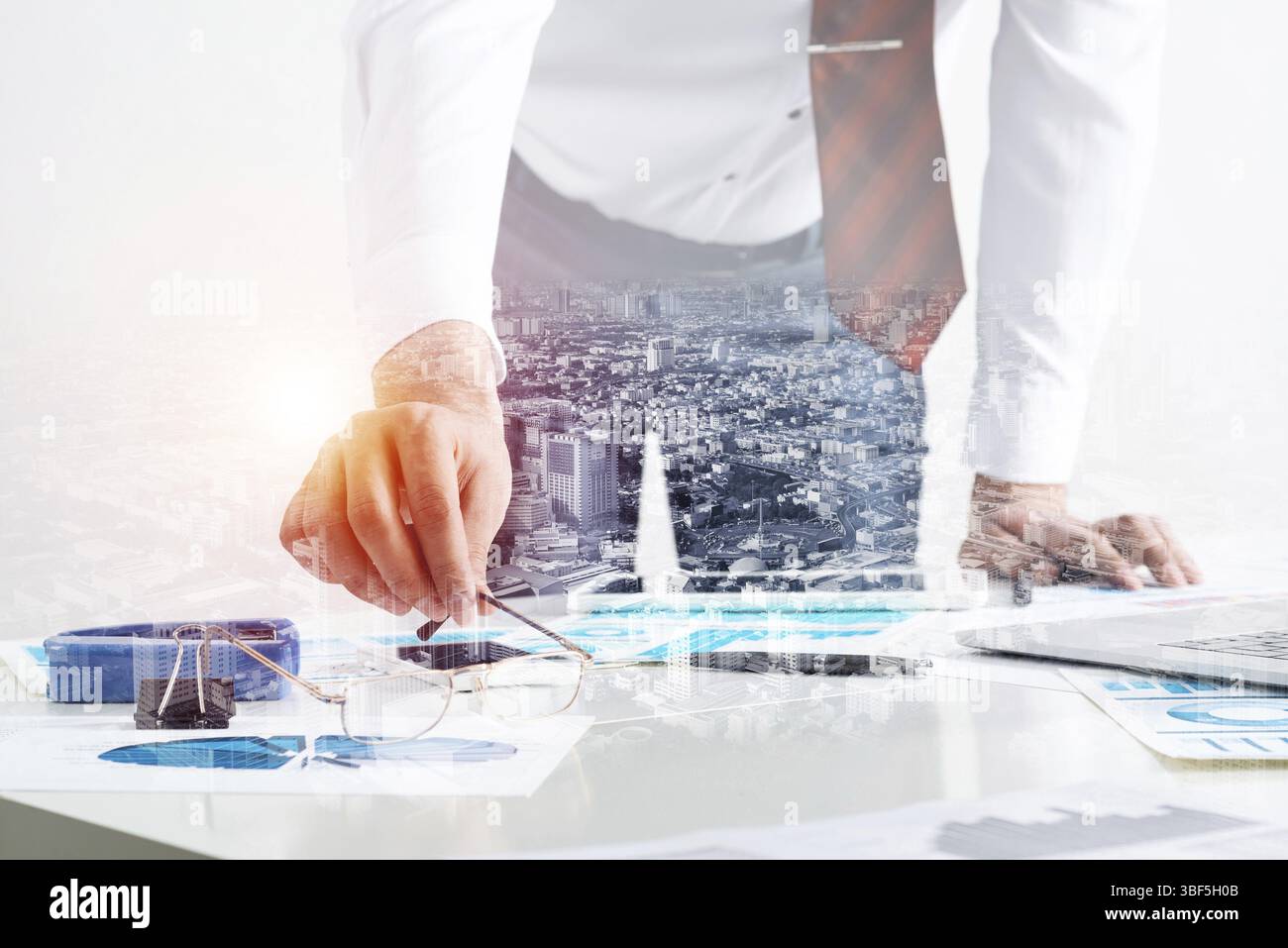 Homme d'affaires se tenant près du bureau et analysant les diagrammes financiers. Directeur d'entreprise réussi en costume et cravate d'affaires. Gros plan main homme avec un Banque D'Images