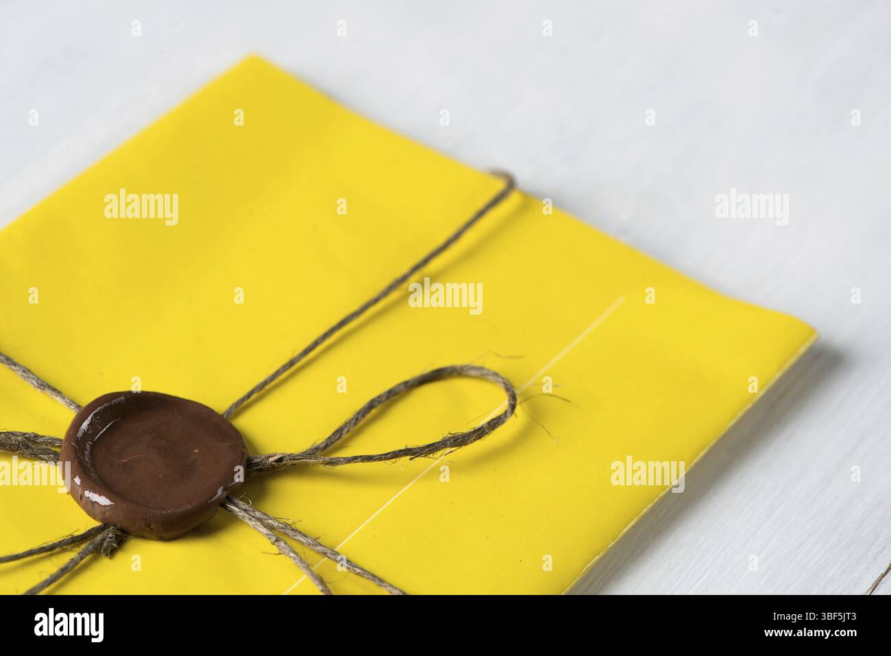 Lettre jaune enveloppe avec cachet de cire sur la surface en bois Banque D'Images