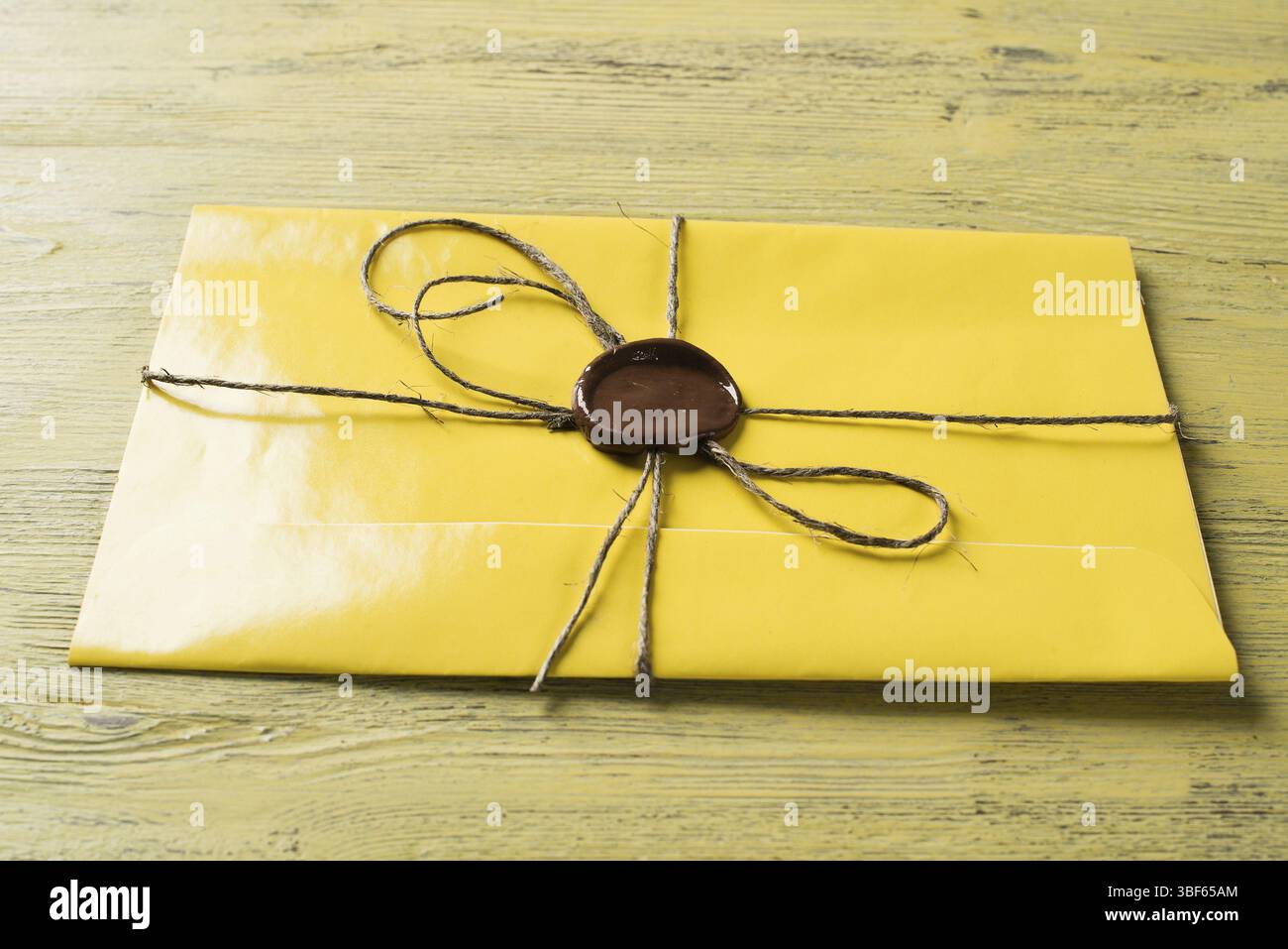 Lettre jaune enveloppe avec cachet de cire sur la surface en bois Banque D'Images