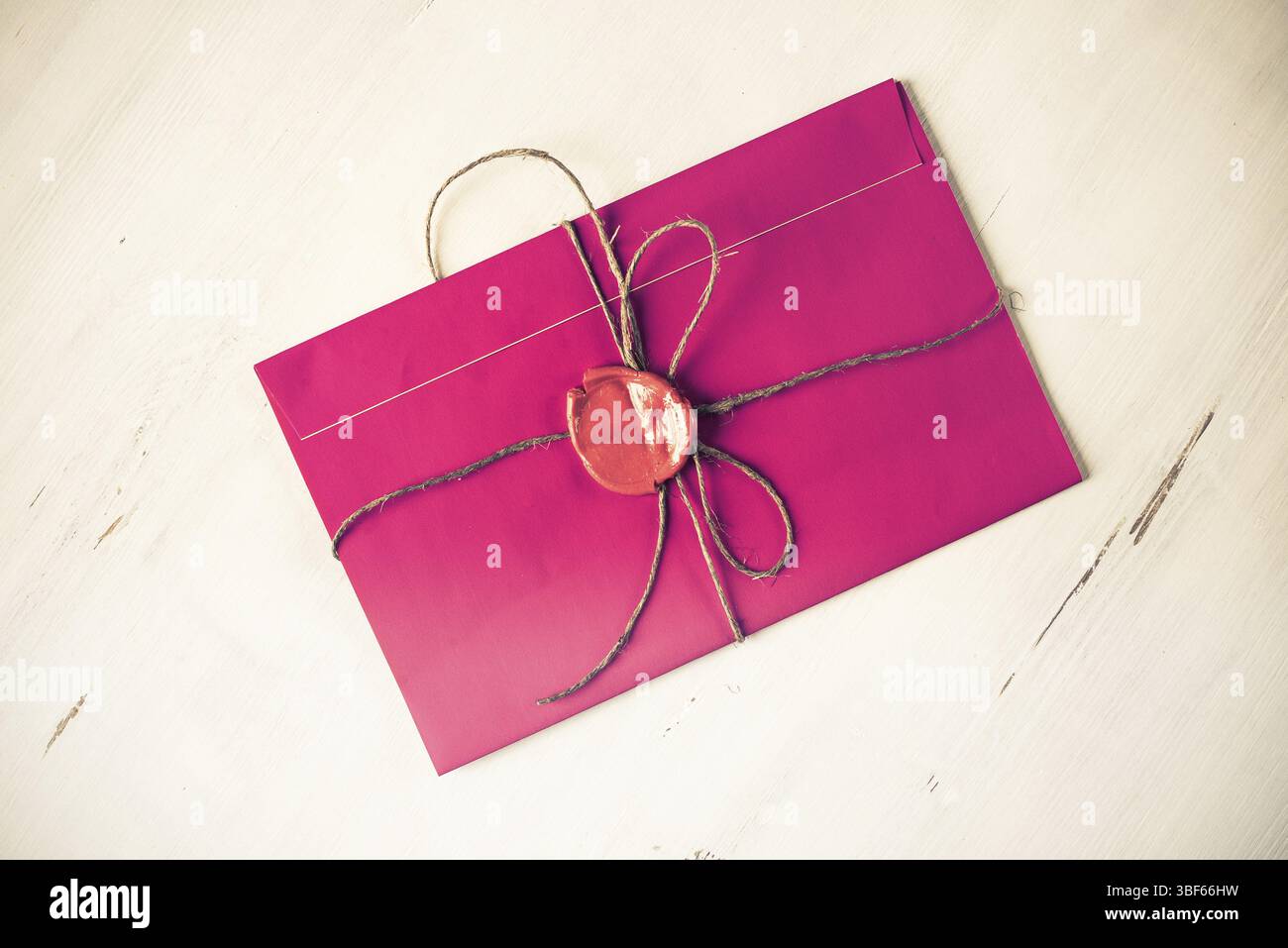 Lettre rose enveloppe avec cachet de cire sur la surface en bois Banque D'Images