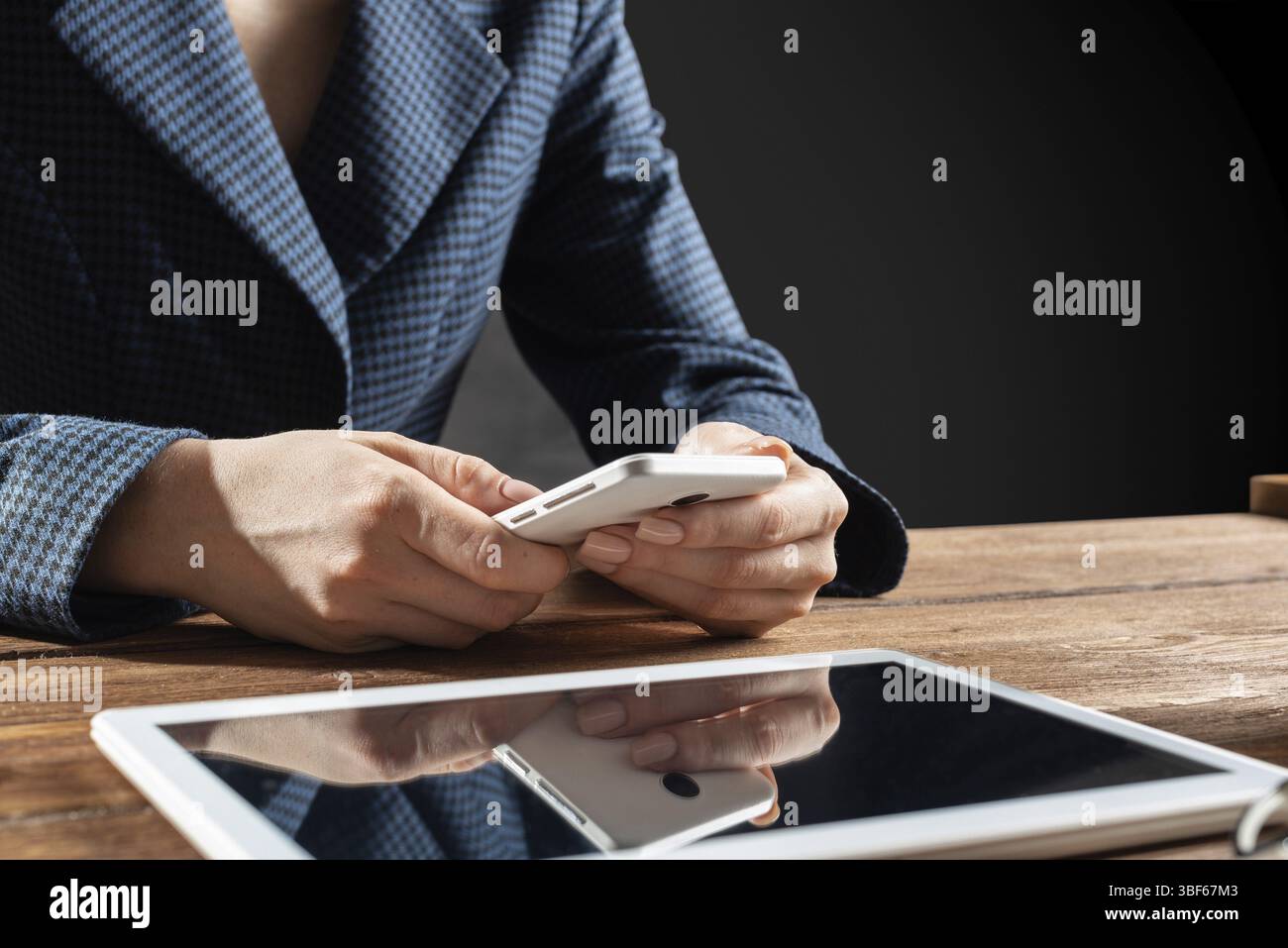 Femme d'affaires utilisant le téléphone portable au bureau. Fermez les mains de la femme et la tablette. Concept de communication mobile avec chat femme. Technolo numérique Banque D'Images