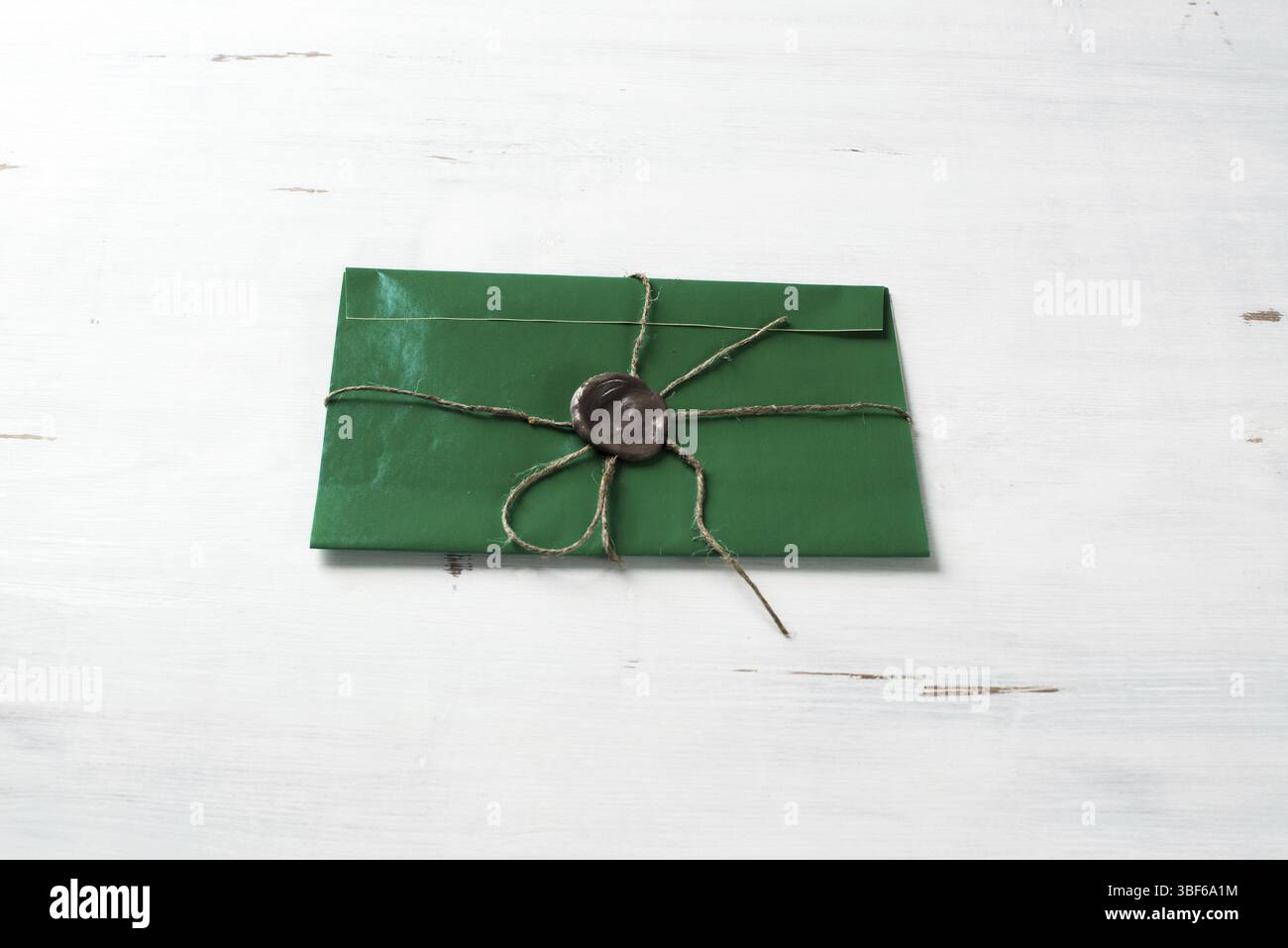 Lettre verte enveloppe avec cachet de cire sur la surface en bois Banque D'Images