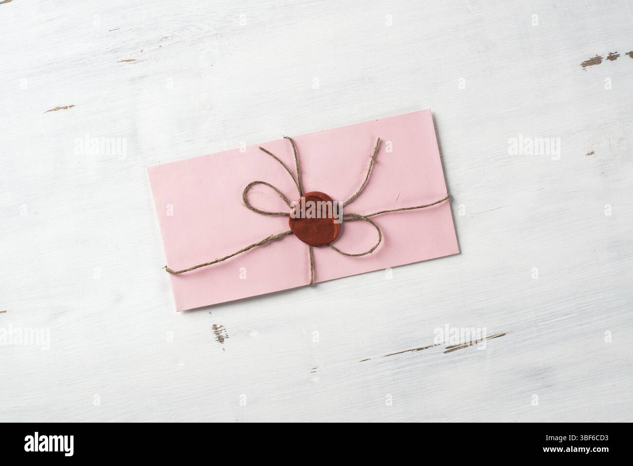 Lettre rose enveloppe avec cachet de cire sur la surface en bois Banque D'Images
