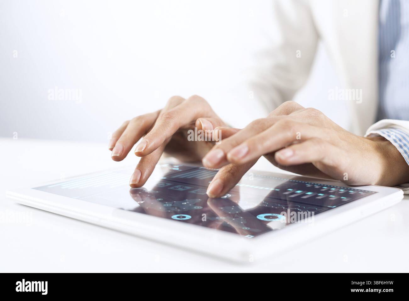 Courtier en costume blanc à l'aide de l'ordinateur tablette pour l'analyse des données financières. Close-up of male hands touching screen de tablette. Bourse en ligne Banque D'Images