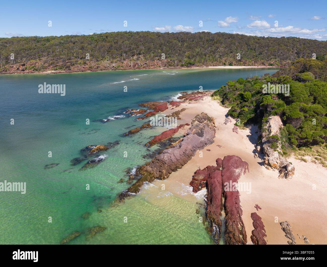 Vue aérienne de couches de roche rouge à l'embouchure d'une rivière côtière à Pambula Beach sur la Sapphire Coast de Nouvelle-Galles du Sud en Australie. Banque D'Images