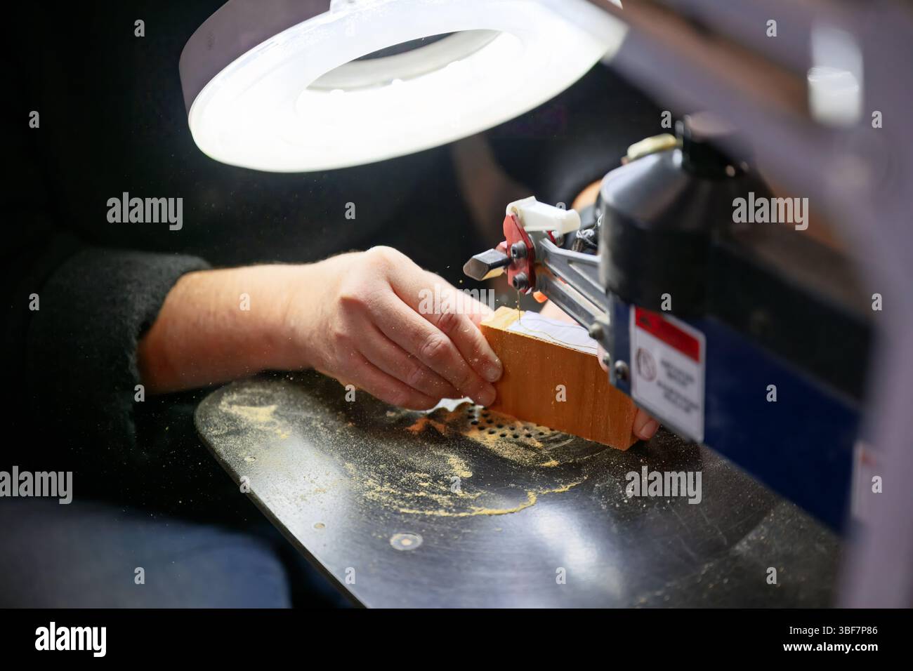 Scie à rouleaux, fabrication de jouet enfant en bois, coupe la forme dans le bois avec scie à ruban dans l'atelier Banque D'Images