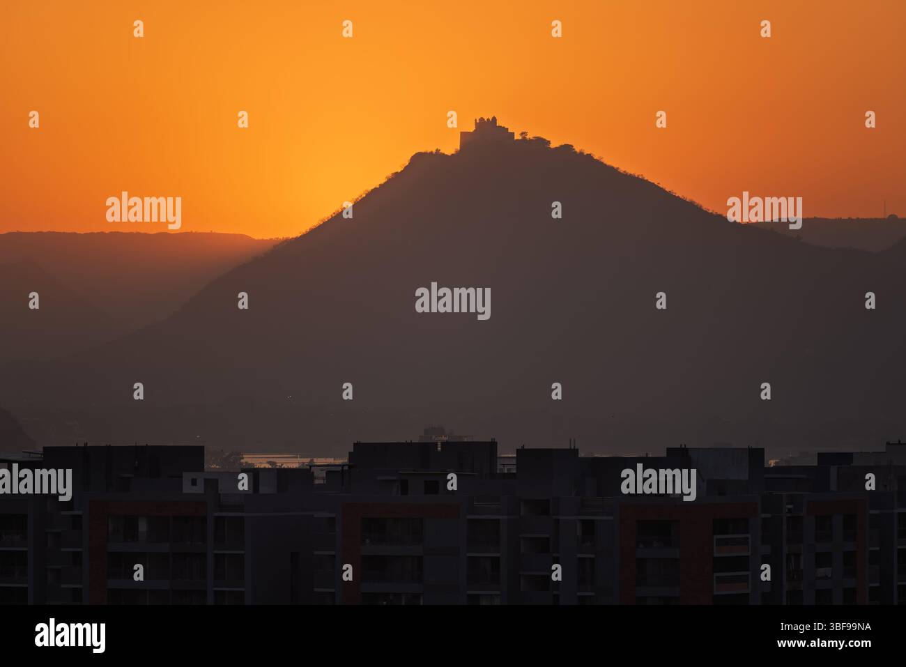 Coucher de soleil sur le Palais de la mousson, Udaipur, Inde. Le Palais de la mousson (Palais de Sajjan Garh) est situé sur une colline dans la chaîne Aravalli, surplombant Udaipur, Rajasthan, Inde. Construit en 1884 par Maharana Sajjan Singh de la dynastie Mewar, le palais a été conçu comme un refuge pour observer les nuages de mousson et comme une résidence d'été. Offrant une vue panoramique sur la ville d'Udaipur, le lac Fateh Sagar et les collines environnantes, le palais est une destination touristique populaire, en particulier pour les couchers de soleil et sa beauté architecturale. Banque D'Images