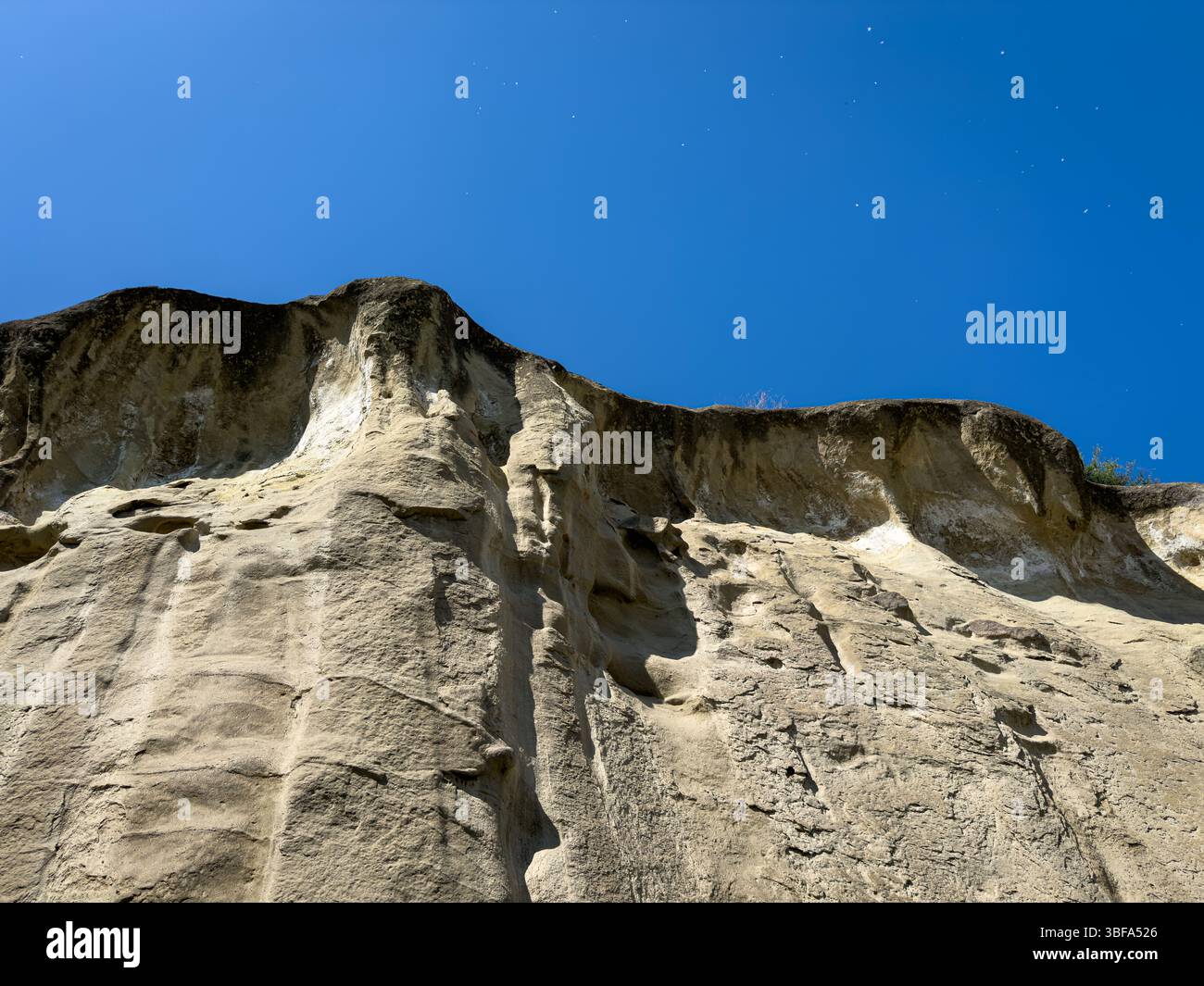 Vue rapprochée des falaises rocheuses et du mur de grès texturé dans la ville grotte d'Uplistsikhe, Géorgie, contre un ciel bleu clair. Personne. Banque D'Images