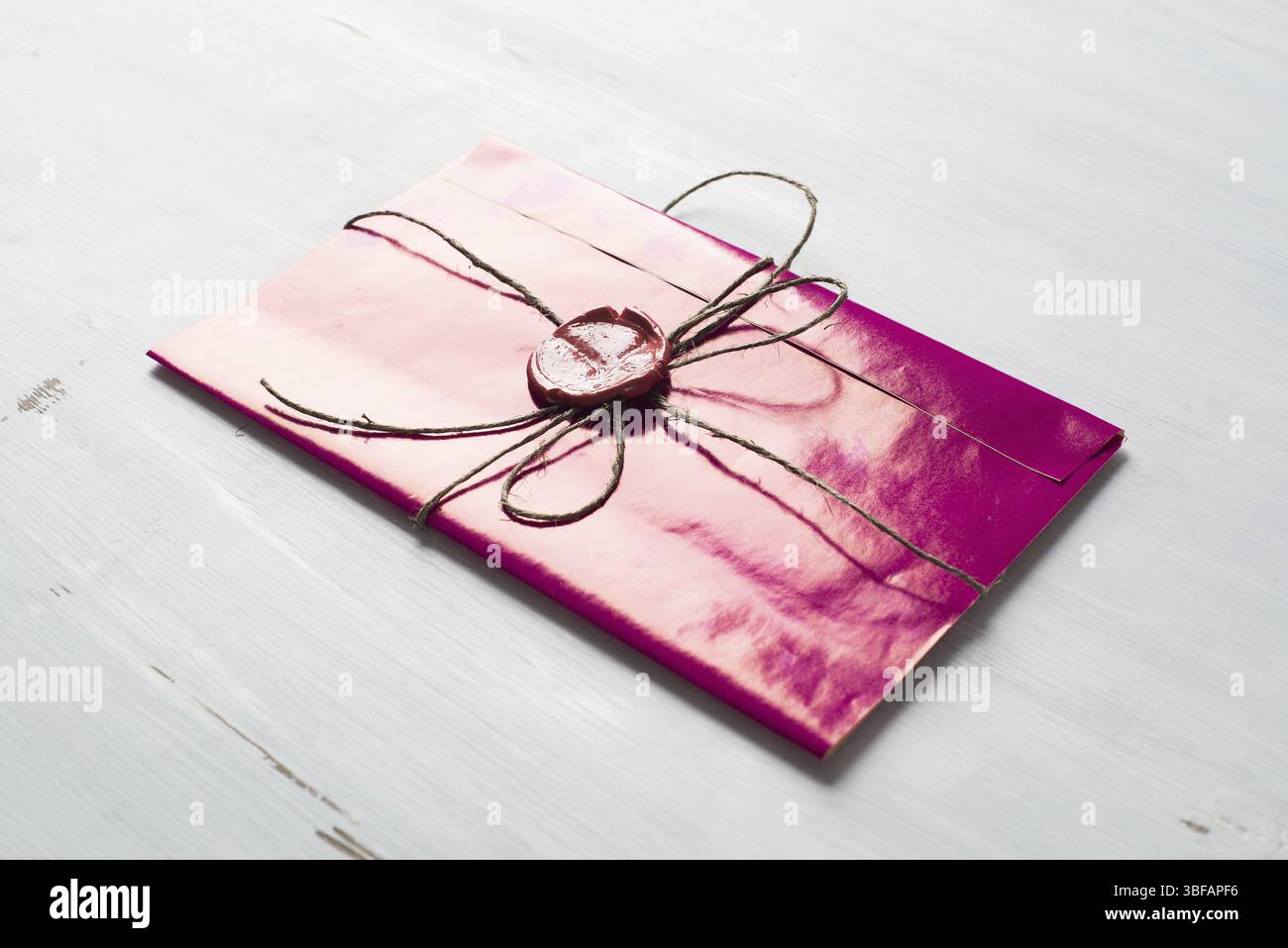 Lettre rose enveloppe avec cachet de cire sur la surface en bois Banque D'Images