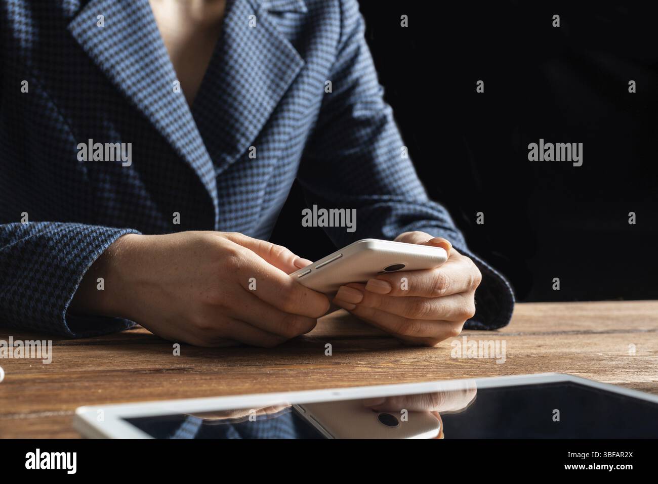 Femme d'affaires utilisant le téléphone portable au bureau. Fermez les mains de la femme et la tablette. Concept de communication mobile avec chat femme. Technolo numérique Banque D'Images