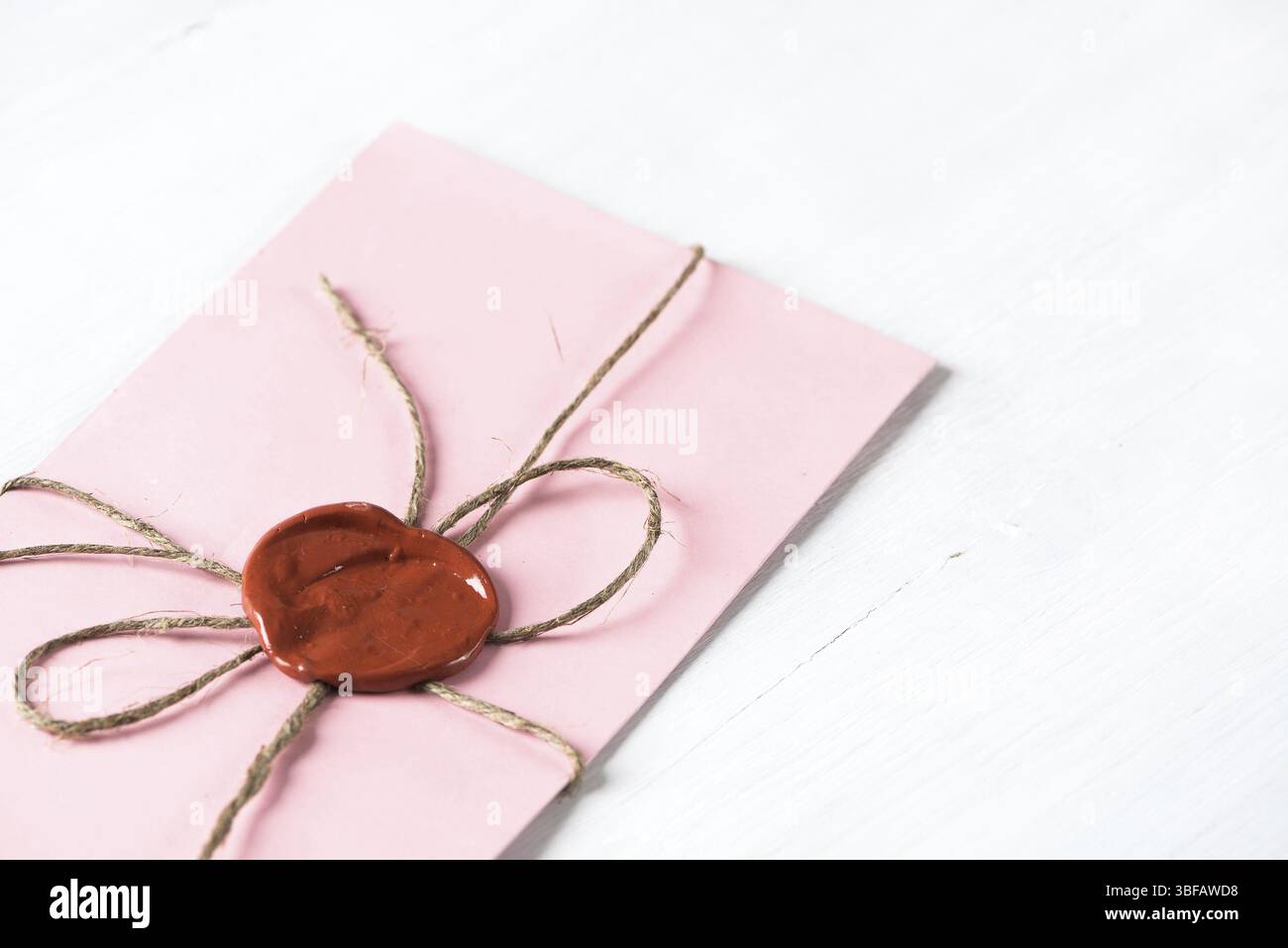 Lettre rose enveloppe avec cachet de cire sur la surface en bois Banque D'Images