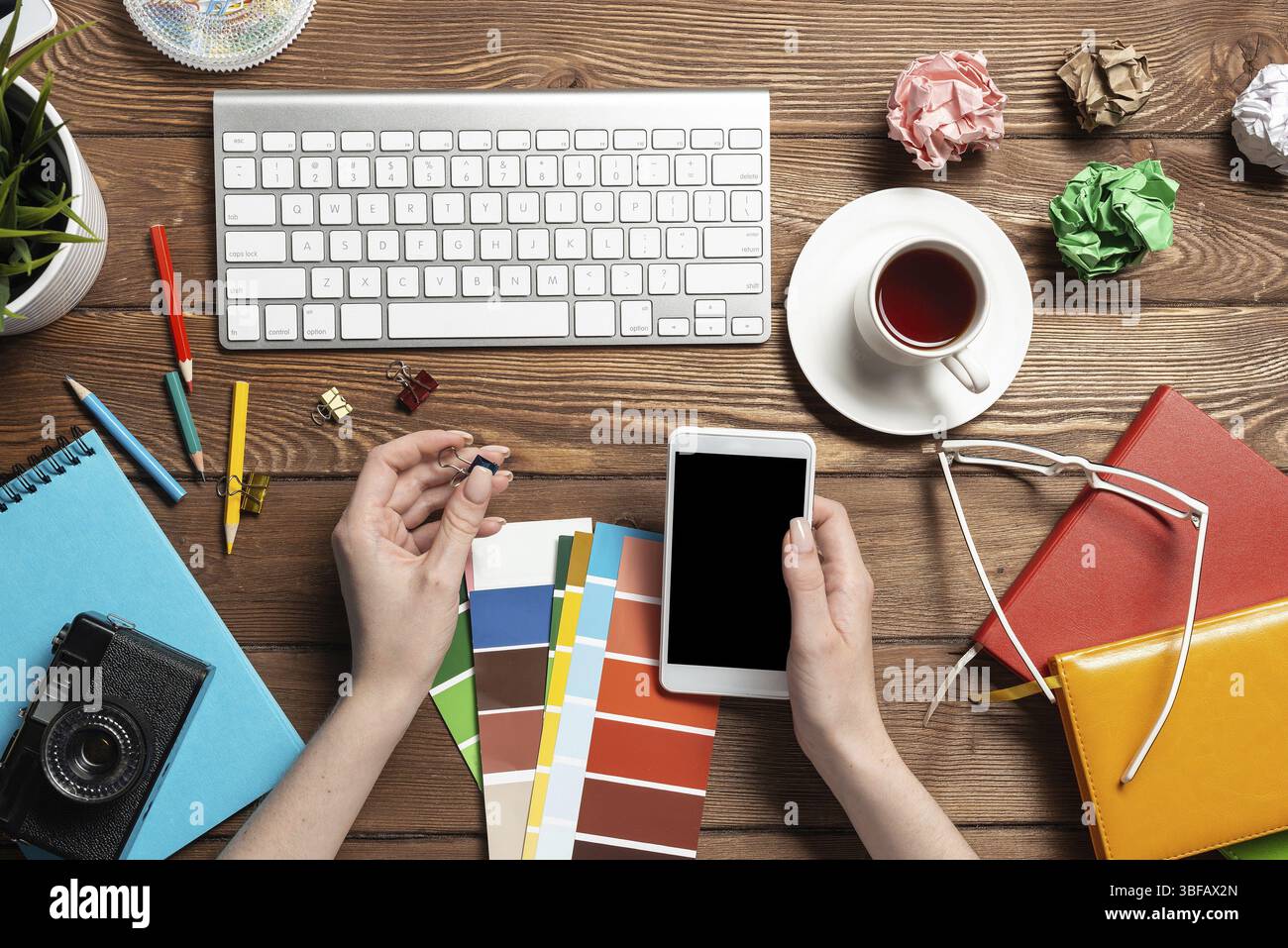 Concepteur Web choisissant des couleurs à partir de nuances au bureau en bois. Bureau vue de dessus avec clavier d'ordinateur et papeterie. Conception de l'interface utilisateur o Banque D'Images