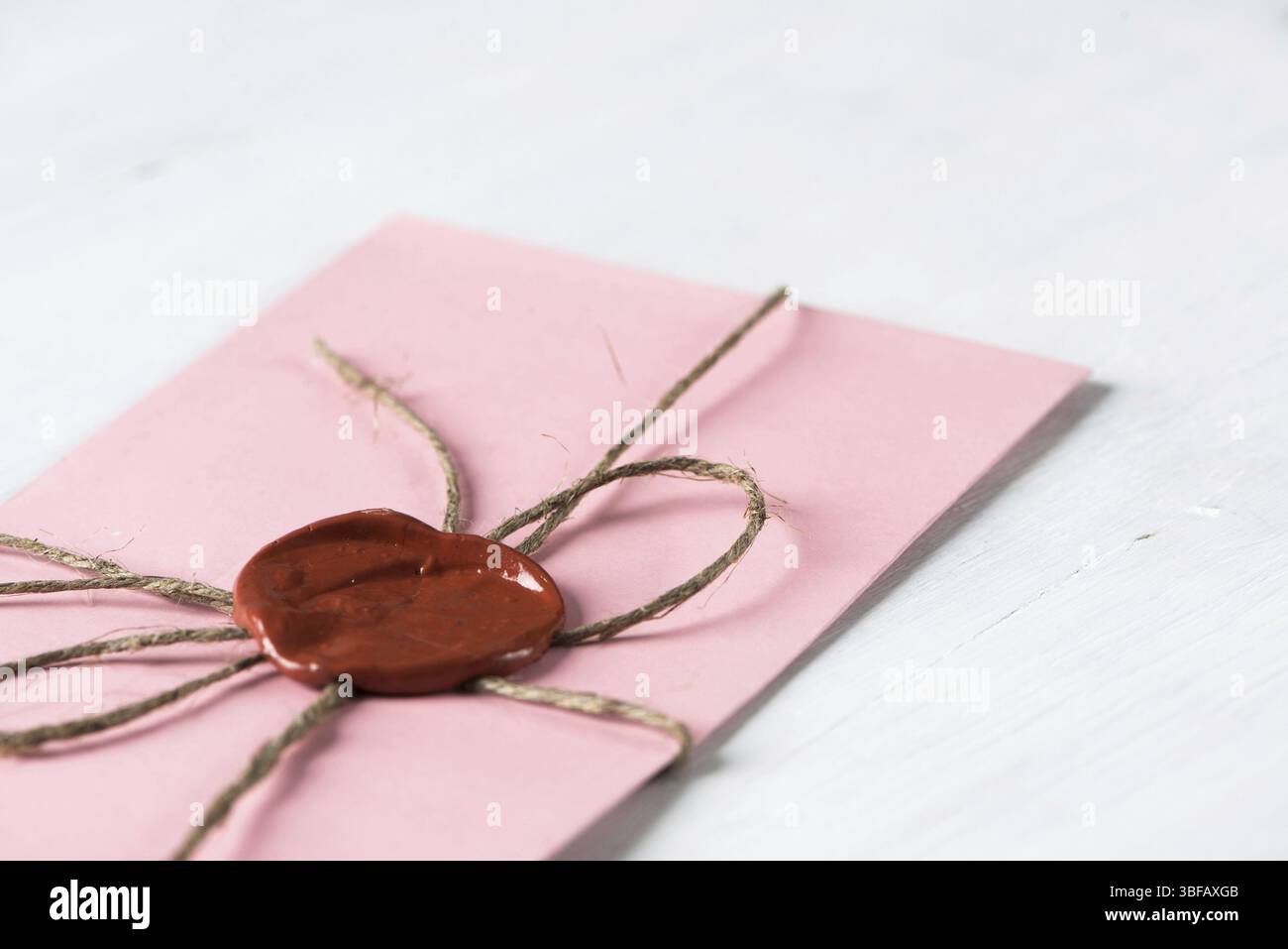 Lettre rose enveloppe avec cachet de cire sur la surface en bois Banque D'Images
