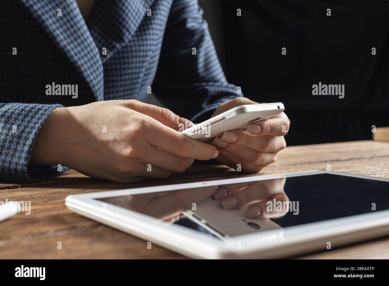 Femme d'affaires utilisant le téléphone portable au bureau. Fermez les mains de la femme et la tablette. Concept de communication mobile avec chat femme. Technolo numérique Banque D'Images