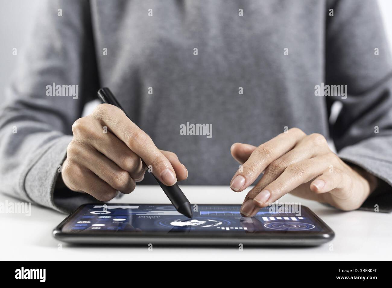 Woman using tablet computer pour la gestion de projet. Close-up of female hand holding pen et de toucher de l'écran tablet device. Bourse en ligne et Banque D'Images