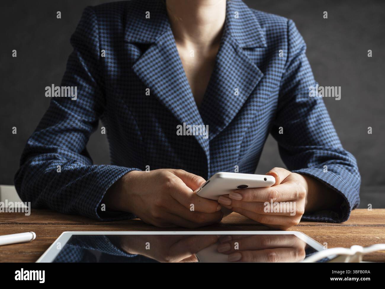 Femme d'affaires utilisant le téléphone portable au bureau. Fermez les mains de la femme et la tablette. Concept de communication mobile avec chat femme. Technolo numérique Banque D'Images