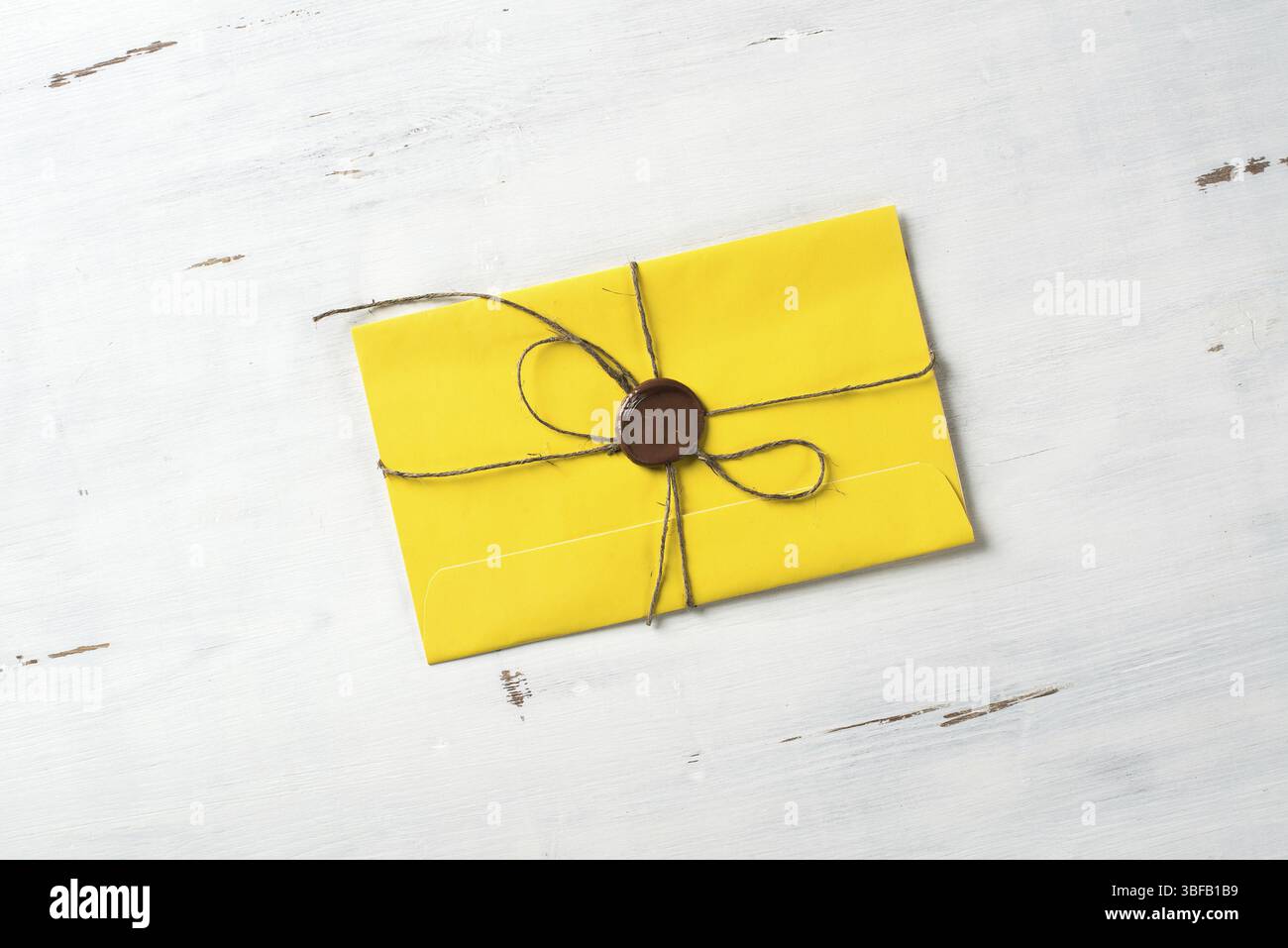 Lettre jaune enveloppe avec cachet de cire sur la surface en bois Banque D'Images