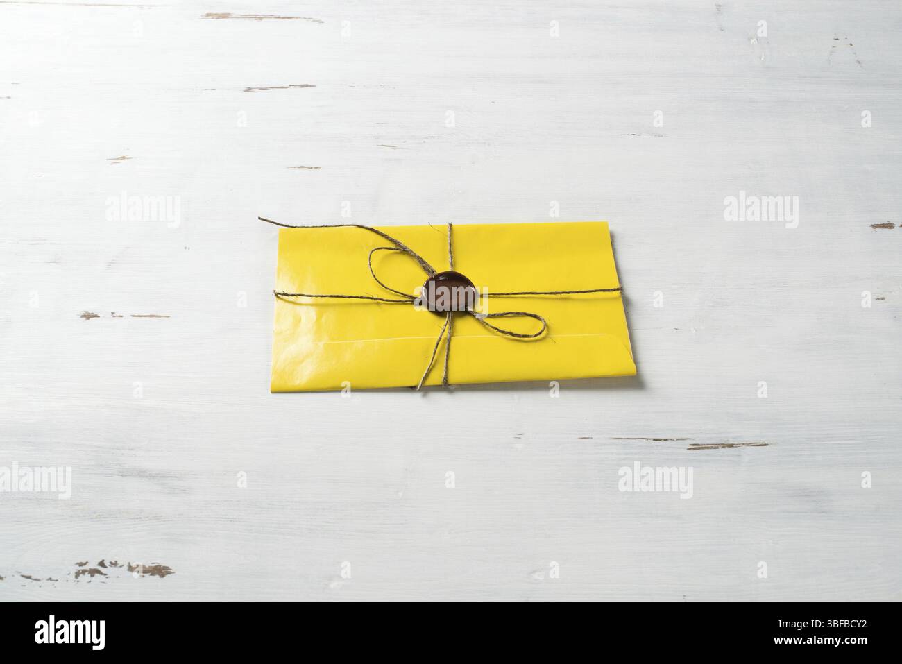 Lettre jaune enveloppe avec cachet de cire sur la surface en bois Banque D'Images