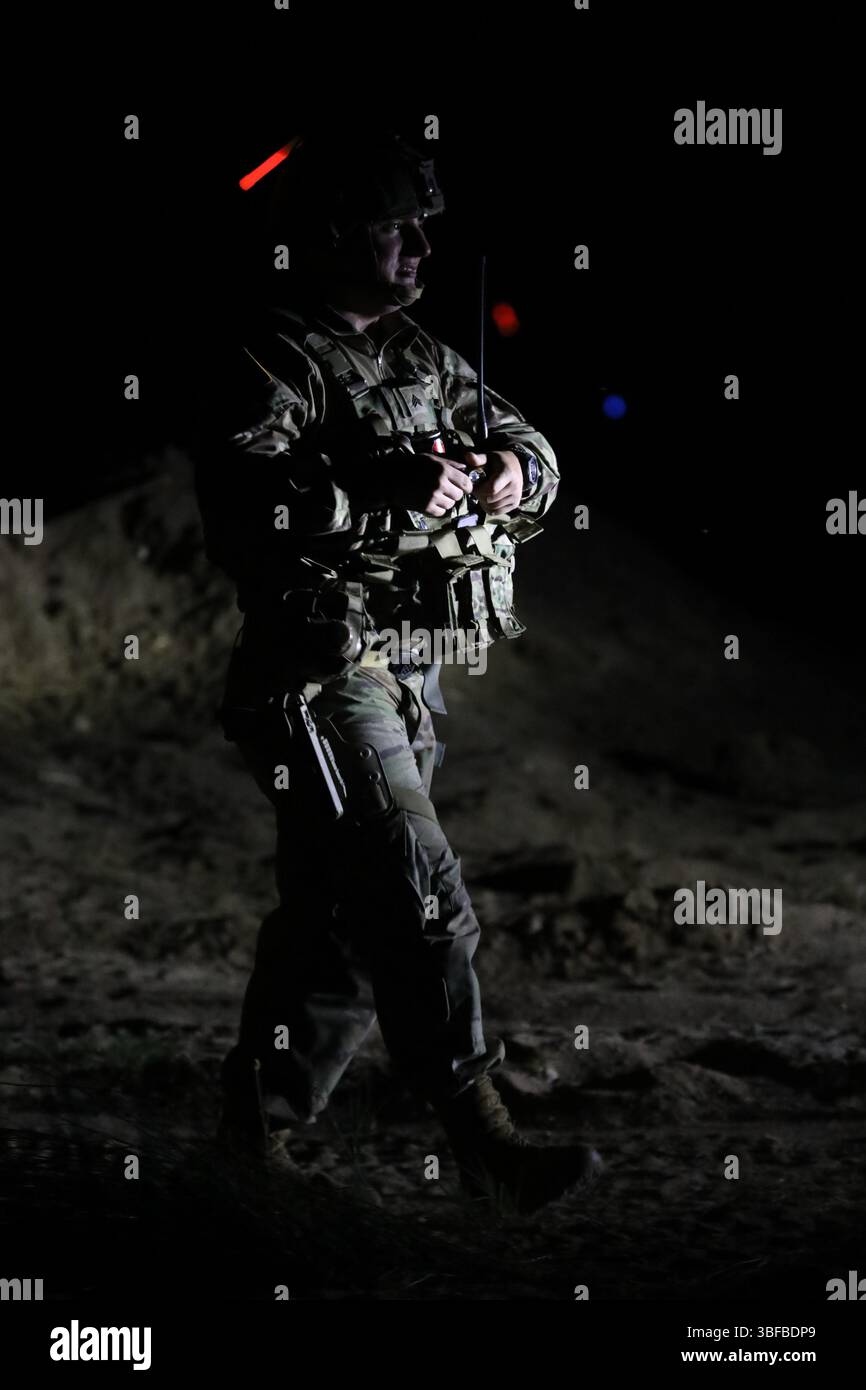 Un soldat de l'armée américaine affecté à la 252e compagnie de police militaire de la Garde nationale de l'armée du Tennessee, se prépare à déployer son phare pour améliorer la visibilité et la sécurité lors des opérations nocturnes sur la rivière Nestos en Grèce, le 29 mai 2025. Le soldat faisait partie d'un effort multinational de soutien à un passage humide au cours de la partie intervention immédiate du DEFENDER 25. Les unités opèrent toute la nuit sous un éclairage limité, menant des opérations 24 heures sur 24 pour assurer le succès de la mission avant de retourner dans la zone d'entraînement de Petrochori peu après le lever du soleil le 30 mai. L'exercice a testé une coordination à grande échelle Banque D'Images