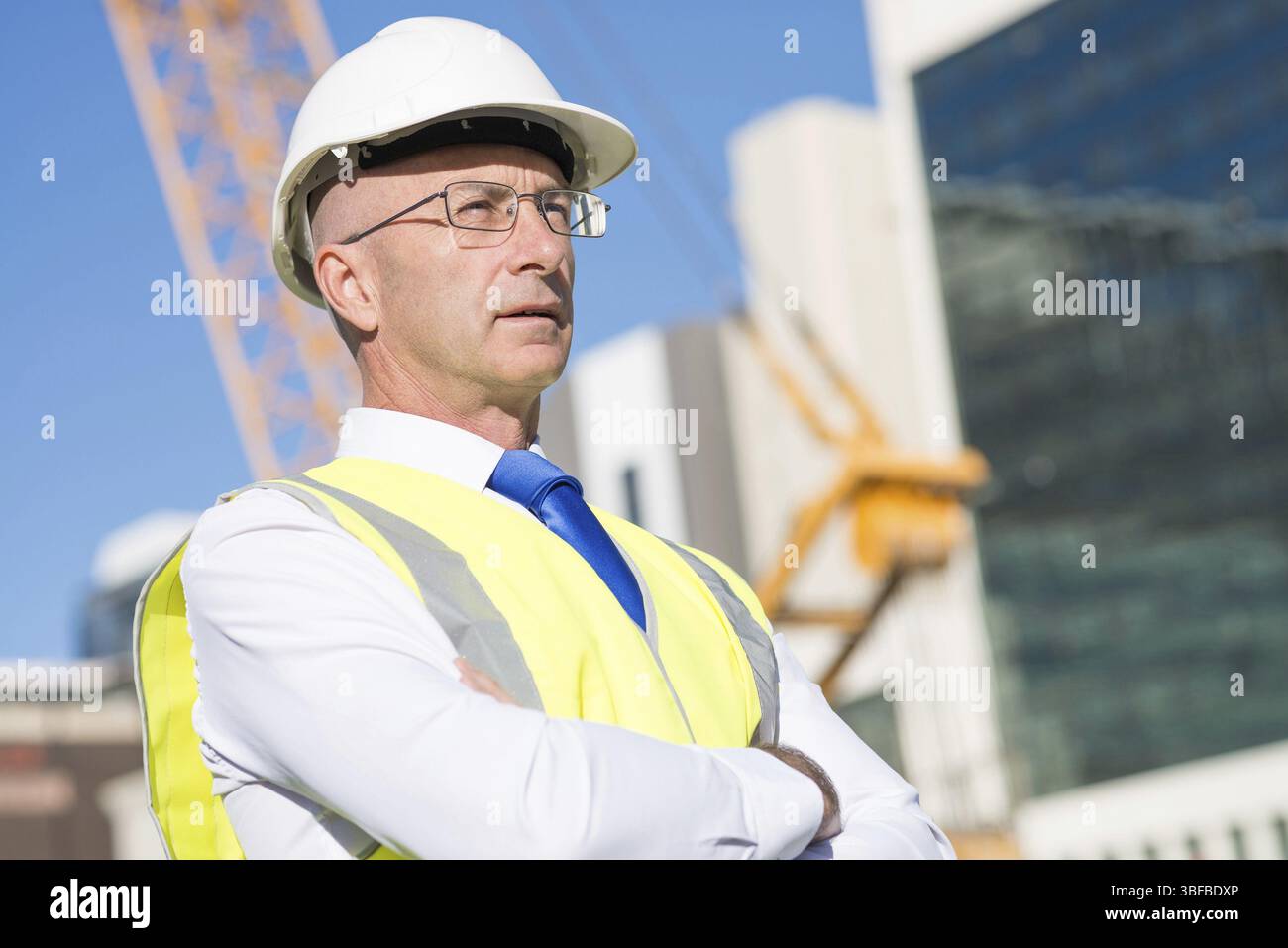 Ingénieur en construction in hardhat confiant avec les bras croisés sur la poitrine Banque D'Images
