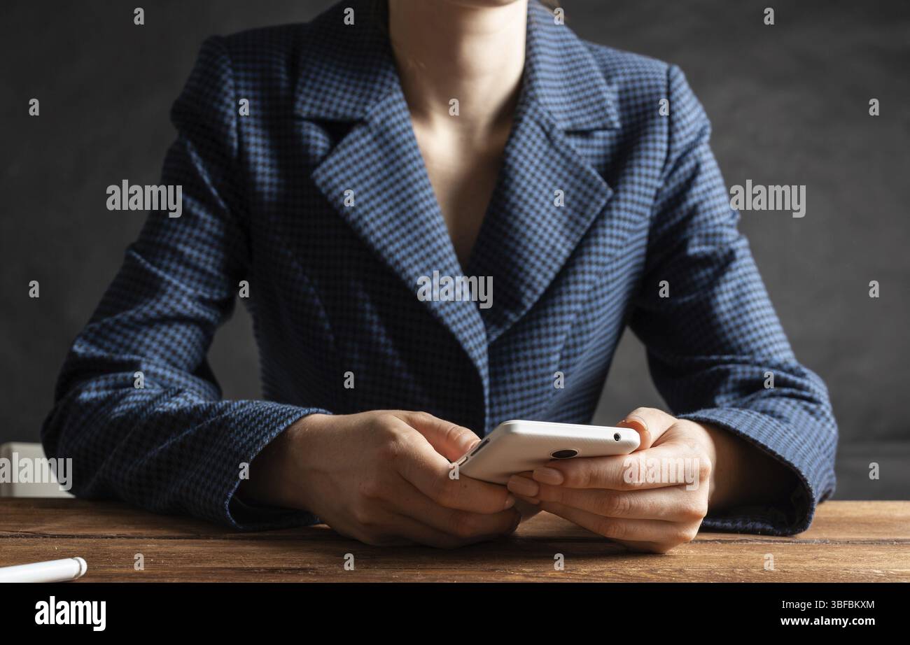 Femme d'affaires utilisant le téléphone portable au bureau. Fermez les mains de la femme et la tablette. Concept de communication mobile avec chat femme. Technolo numérique Banque D'Images