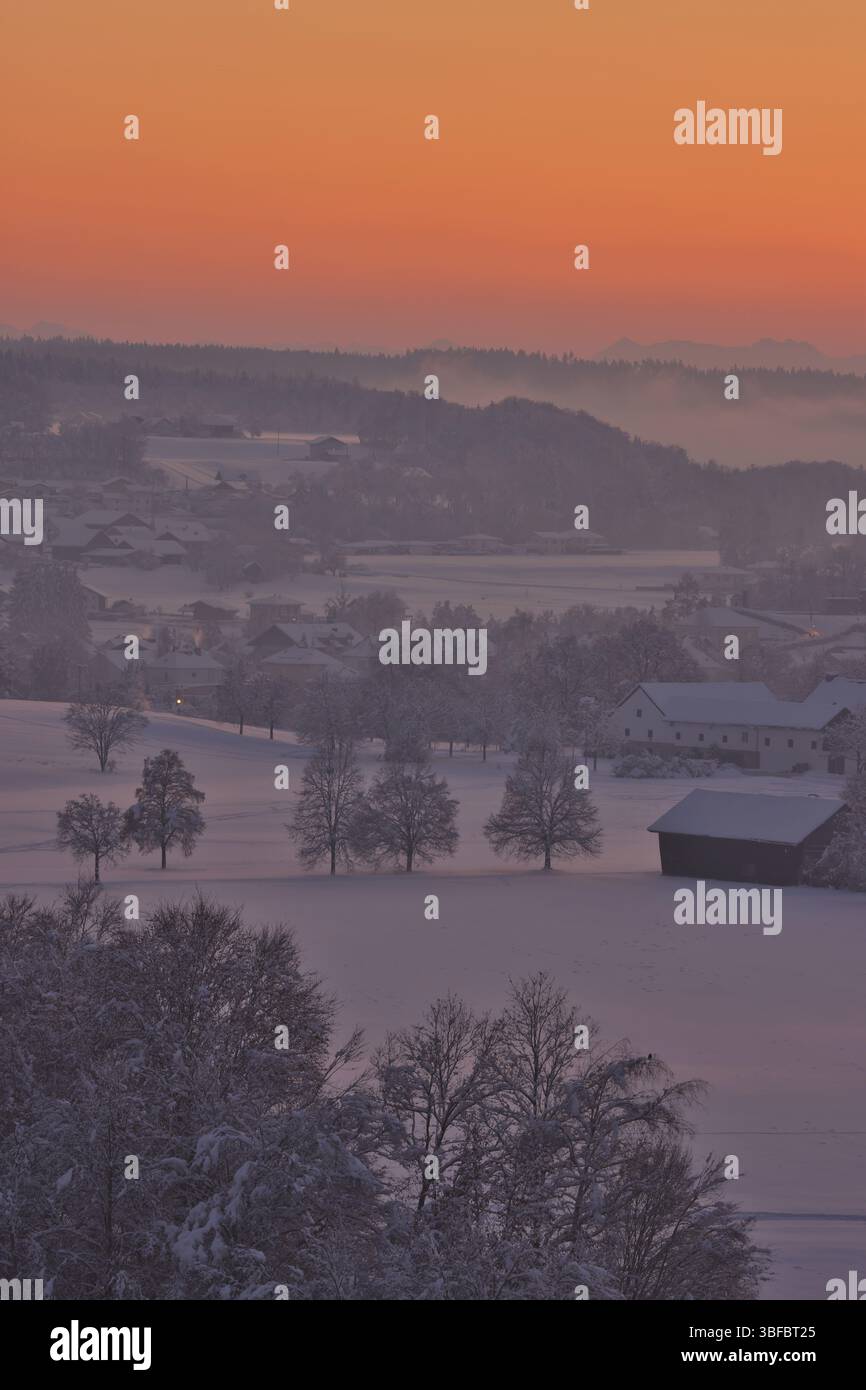 Paysage d'hiver enneigé avec des arbres et des maisons au coucher du soleil, Burghausen, haute-Bavière, Bavière, Allemagne, Europe Banque D'Images
