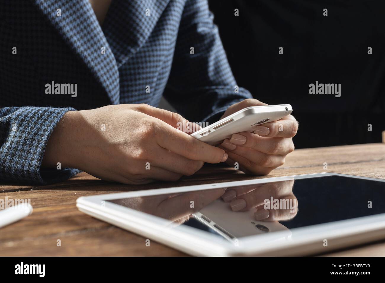Femme d'affaires utilisant le téléphone portable au bureau. Fermez les mains de la femme et la tablette. Concept de communication mobile avec chat femme. Technolo numérique Banque D'Images