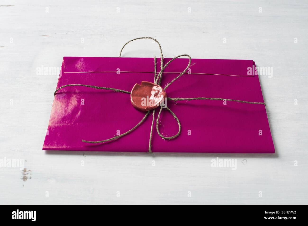 Lettre rose enveloppe avec cachet de cire sur la surface en bois Banque D'Images