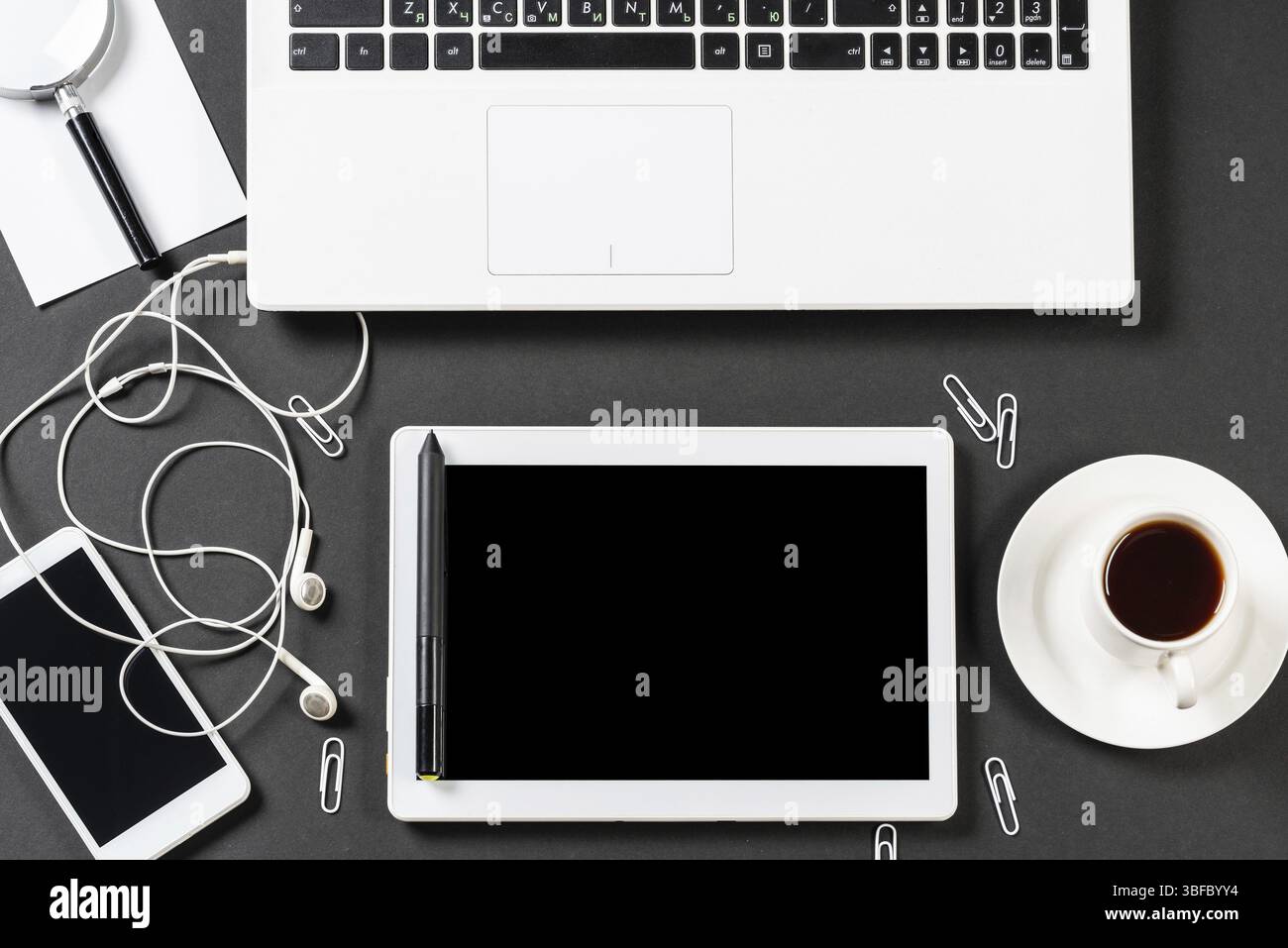 Vue de dessus du lieu de travail design avec des appareils numériques modernes. Design contemporain à plat avec surface noire. Technologie numérique et mode de vie mobile. Banque D'Images