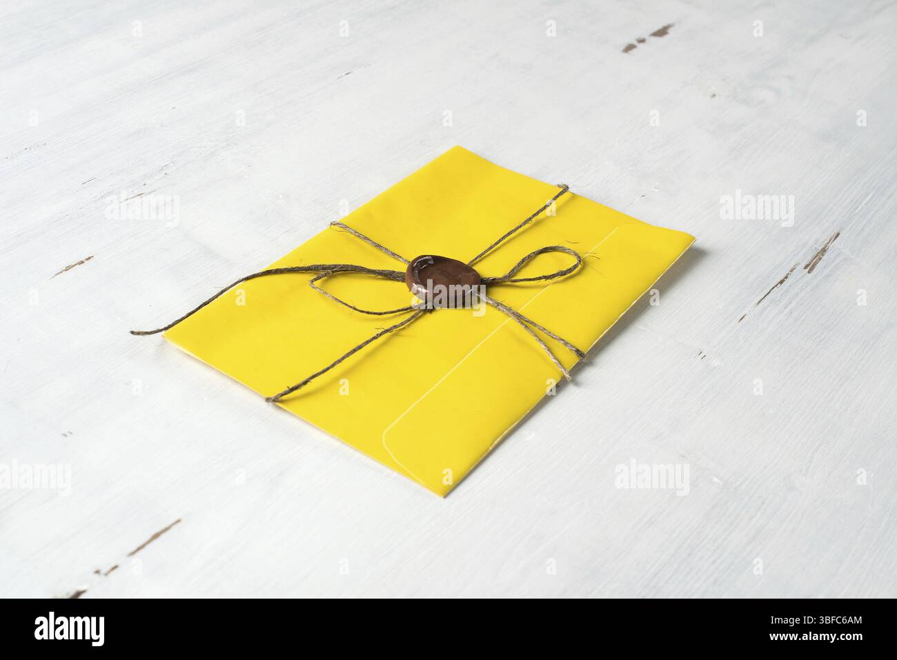 Lettre jaune enveloppe avec cachet de cire sur la surface en bois Banque D'Images