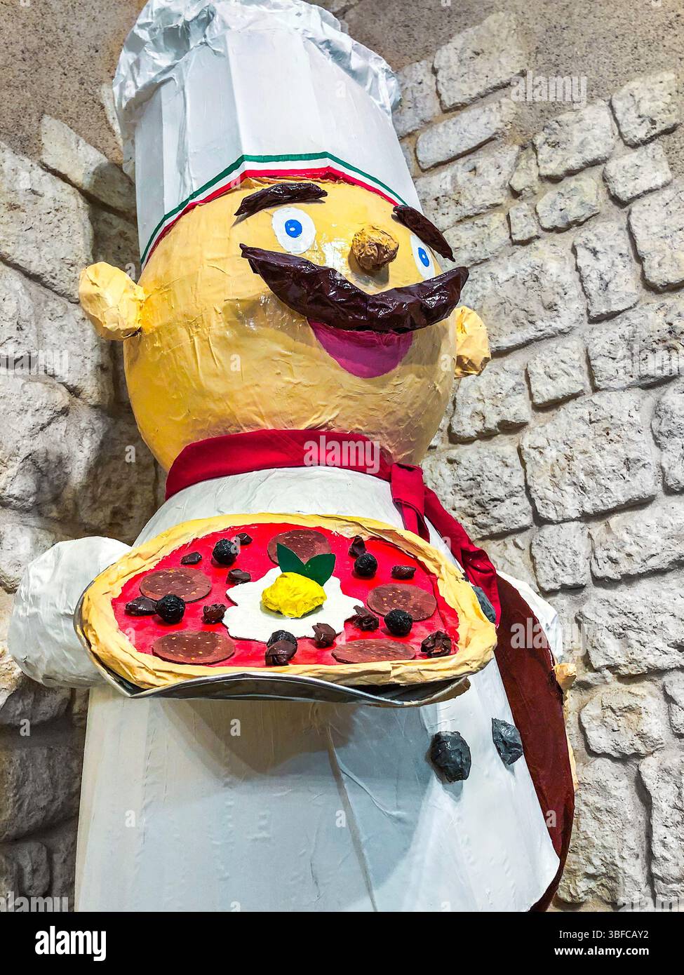 Figurine grandeur nature en papier mâché d'un chef tenant une pizza - Restaurant Pizza Bella, le Blanc, Indre (36), France. Banque D'Images