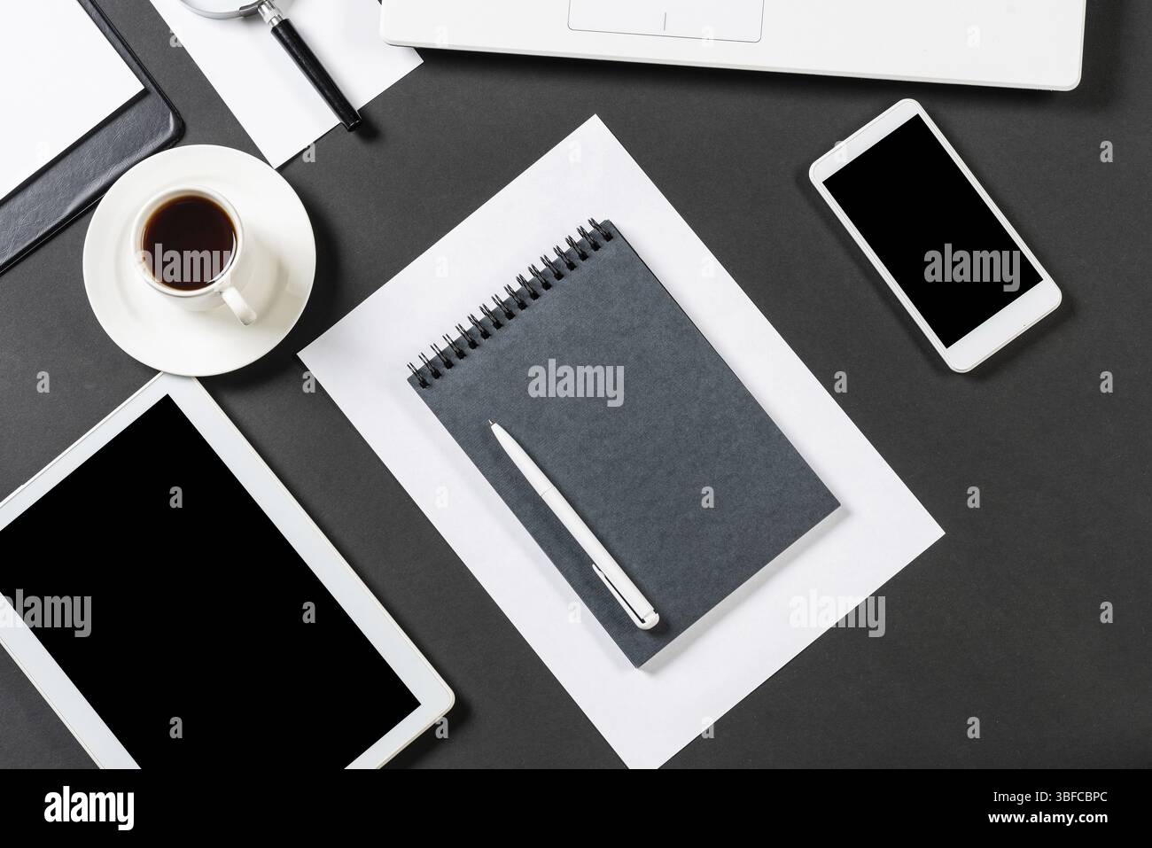 Vue de dessus du lieu de travail design avec des appareils numériques modernes. Design contemporain à plat avec surface noire. Technologie numérique et mode de vie mobile. Banque D'Images