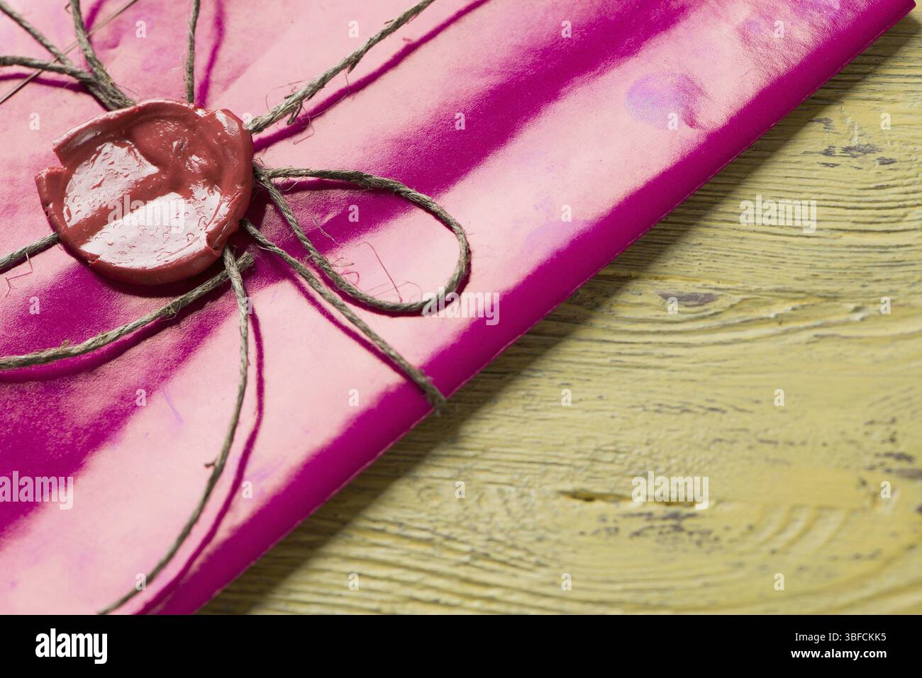 Lettre rose enveloppe avec cachet de cire sur la surface en bois Banque D'Images
