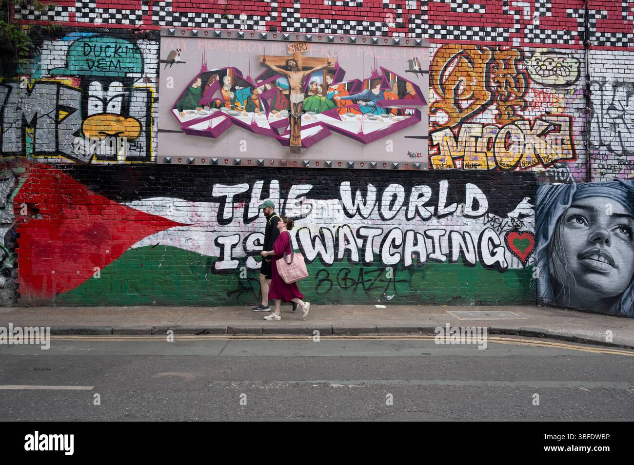 East London. Mur peint Shoreditch - drapeau palestinien et mots « le monde regarde ». Banque D'Images