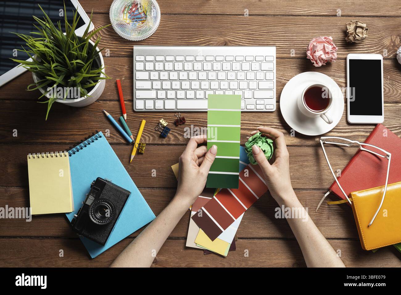 Concepteur Web choisissant des couleurs à partir de nuances au bureau en bois. Bureau vue de dessus avec clavier d'ordinateur et papeterie. Conception de l'interface utilisateur o Banque D'Images