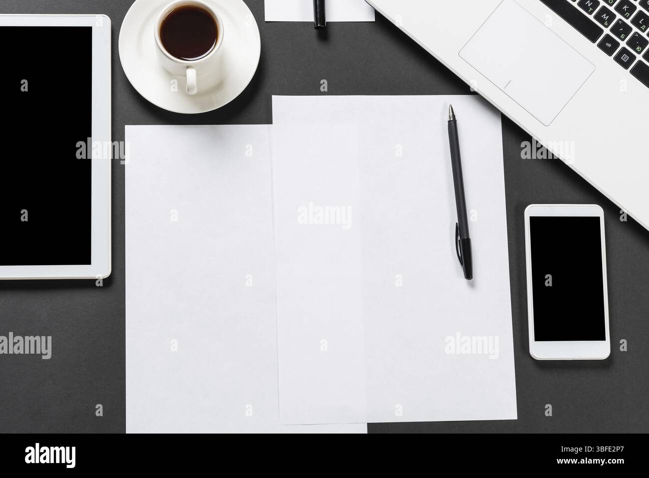 Vue de dessus du lieu de travail design avec des appareils numériques modernes. Design élégant à plat avec surface noire et espace de copie. Technologie numérique et mobile l Banque D'Images