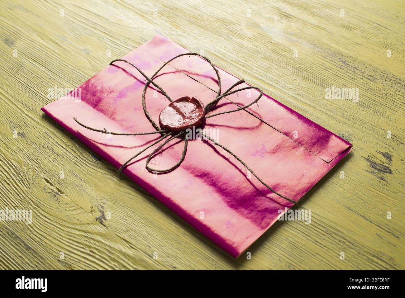 Lettre rose enveloppe avec cachet de cire sur la surface en bois Banque D'Images