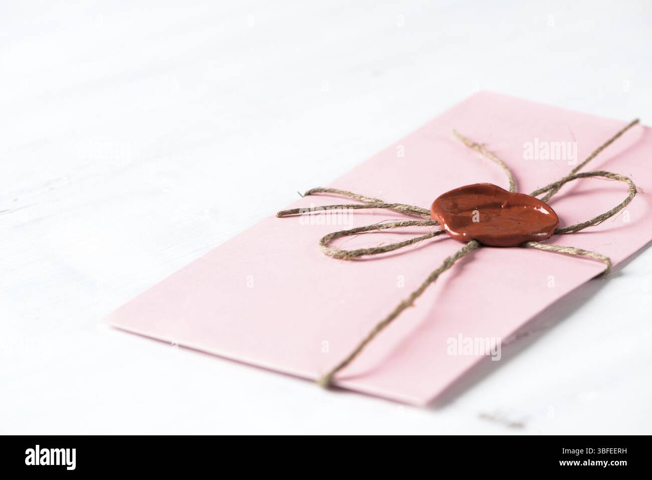 Lettre rose enveloppe avec cachet de cire sur la surface en bois Banque D'Images